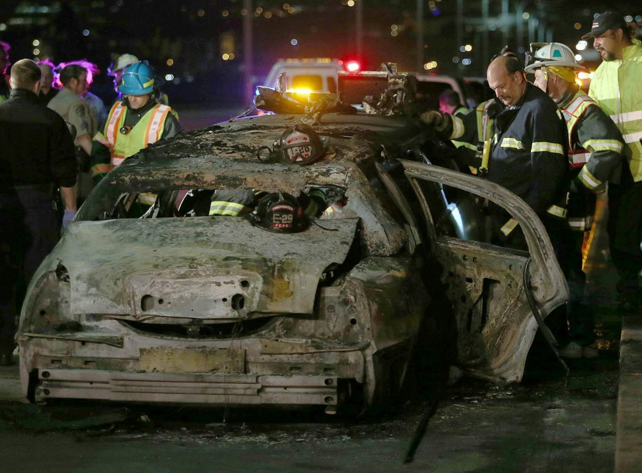 San Mateo County firefighters and California Highway Patrol personnel investigate the scene of a limousine fire on the westbound side of the San Mateo-Hayward Bridge in Foster City, Calif., on Saturday, May 4, 2013. Five people died when they were trapped in the limo that caught fire as they were traveling, and four others and the driver were able to escape, according to the Oakland Tribune-Bay Area News Group.