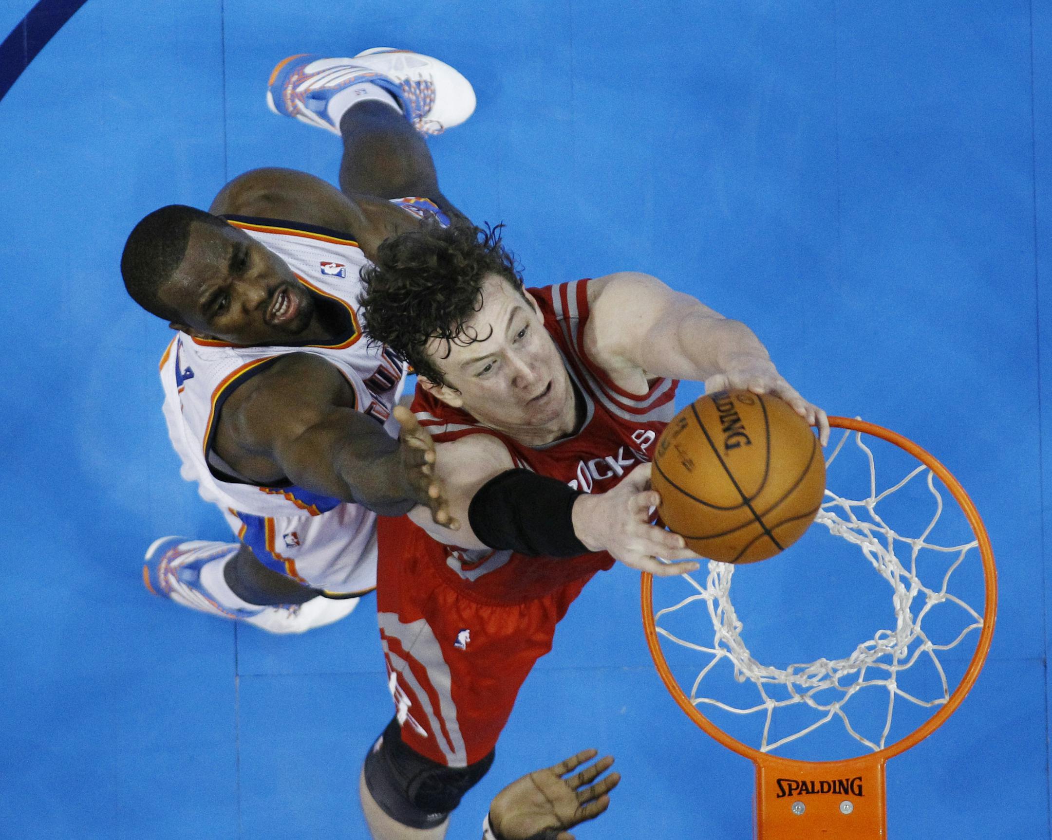 Houston Rockets center Omer Asik (3) dunks in front of Oklahoma City Thunder forward Serge Ibaka (9) in the third quarter of Game 1 of their first-round NBA basketball playoff series in Oklahoma City, Sunday, April 21, 2013. Oklahoma City won 120-91. (AP Photo/Sue Ogrocki)