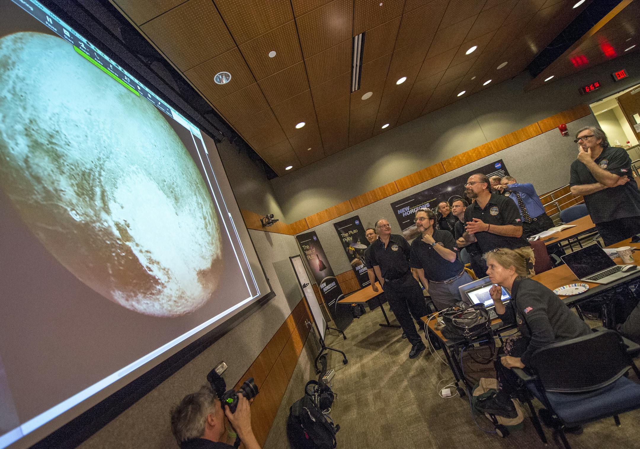 Members of the New Horizons science team react&#x2020;to&#x2020;seeing the&#x2020;spacecraft's&#x2020;last and sharpest&#x2020;image of Pluto before closest approach later in the day, Tuesday, July 14, 2015, at the Johns Hopkins University Applied Physics Laboratory (APL) in Laurel, Maryland. NASA's New Horizons spacecraft was on track to zoom within 7,800 miles (12,500 kilometers) of Pluto on Tuesday. (Bill Ingalls/NASA via AP)