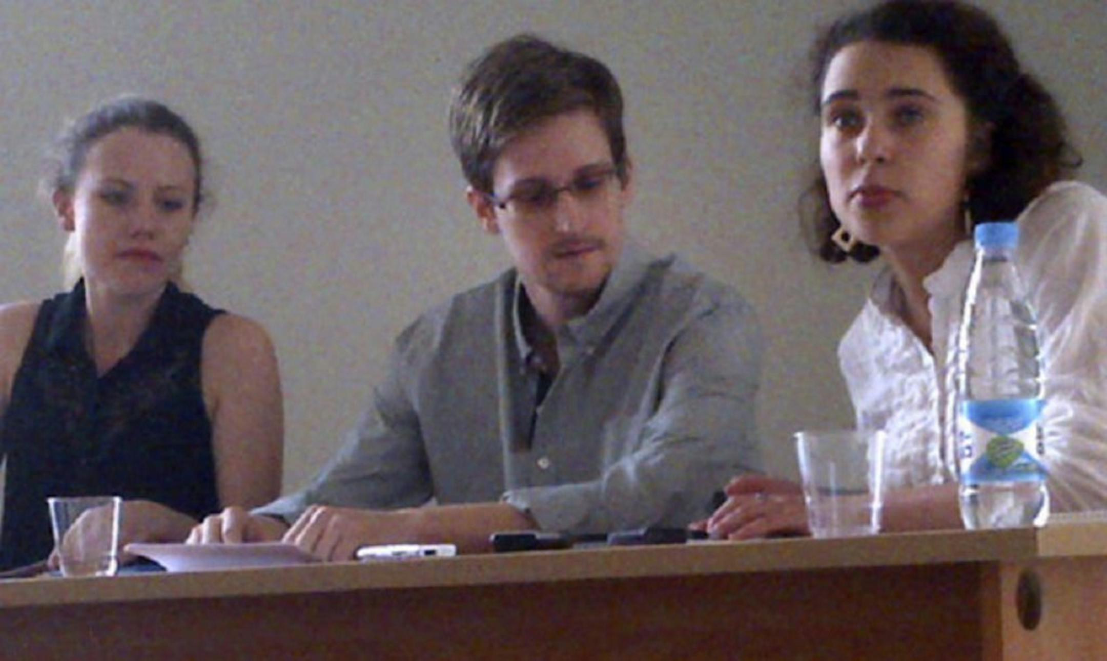 In this image provided by Human Rights Watch, NSA leaker Edward Snowden, center, attends a news conference at Moscow's Sheremetyevo Airport with Sarah Harrison of WikiLeaks, left, Friday, July 12, 2013.