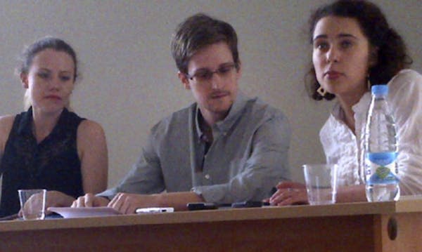 In this image provided by Human Rights Watch, NSA leaker Edward Snowden, center, attends a news conference at Moscow's Sheremetyevo Airport with Sarah