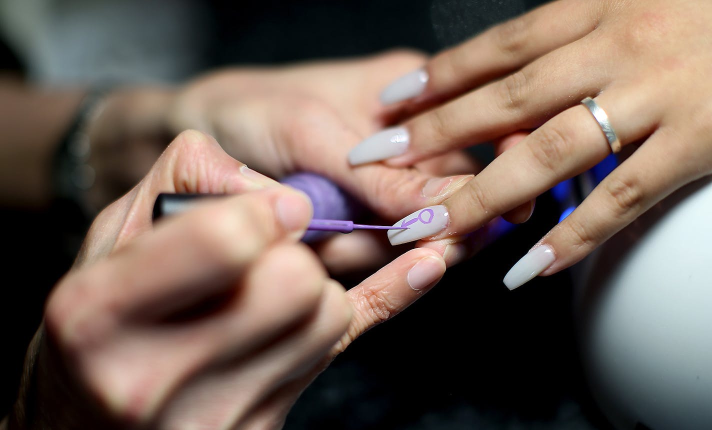 Lauren Salgado watched as nail technician Julie Nghi, cq, worked on her nails at USA Nails, Friday, April 22, 2016 in St. Louis Park, MN. Salgado was there to get the Prince sign painted on her nails in honor of him. ] (ELIZABETH FLORES/STAR TRIBUNE) ELIZABETH FLORES &#x2022; eflores@startribune.com