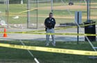 A police office stands watch behind police tape near strewn baseballs on a field in Alexandria, Va., Wednesday, June 14, 2017, after a multiple shooti