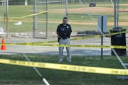 A police office stands watch behind police tape near strewn baseballs on a field in Alexandria, Va., Wednesday, June 14, 2017, after a multiple shooti