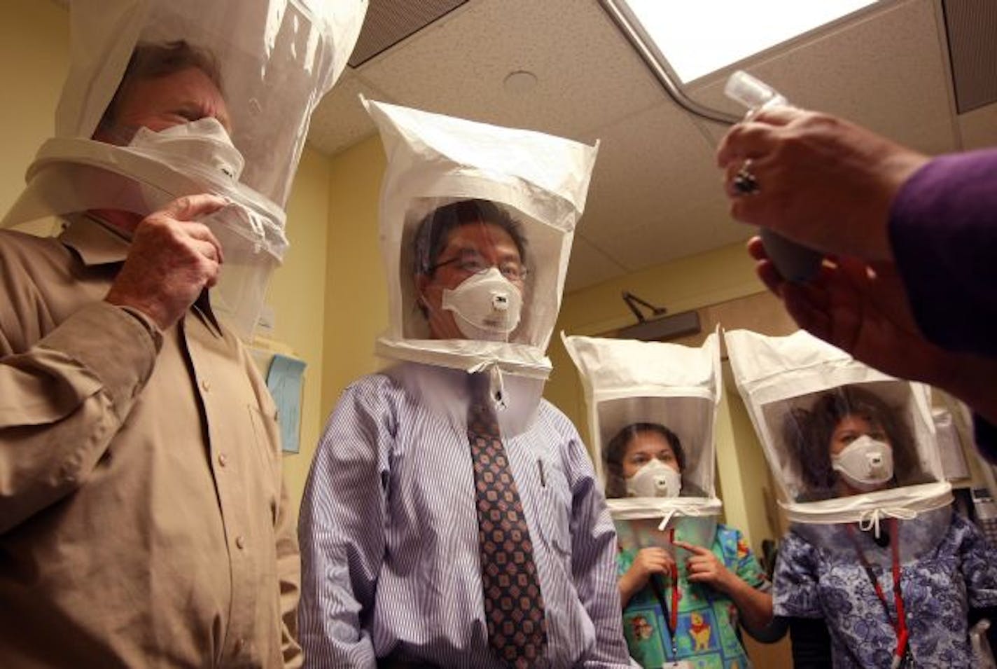 Doctors and nurses wear hoods as they test the seal of N95 respiratory masks during a training at the La Clinica San Antonio Neighborhood Health Center April 28, 2009 in Oakland, California. As the number of swine flu cases in the U.S. continues to rise, doctors and nurses at La Clinica's 26 facilities are being trained to use the N95 respiratory mask to be worn if they come in contact with a patient wo is suspected of having the swine flu or tuberculosis.