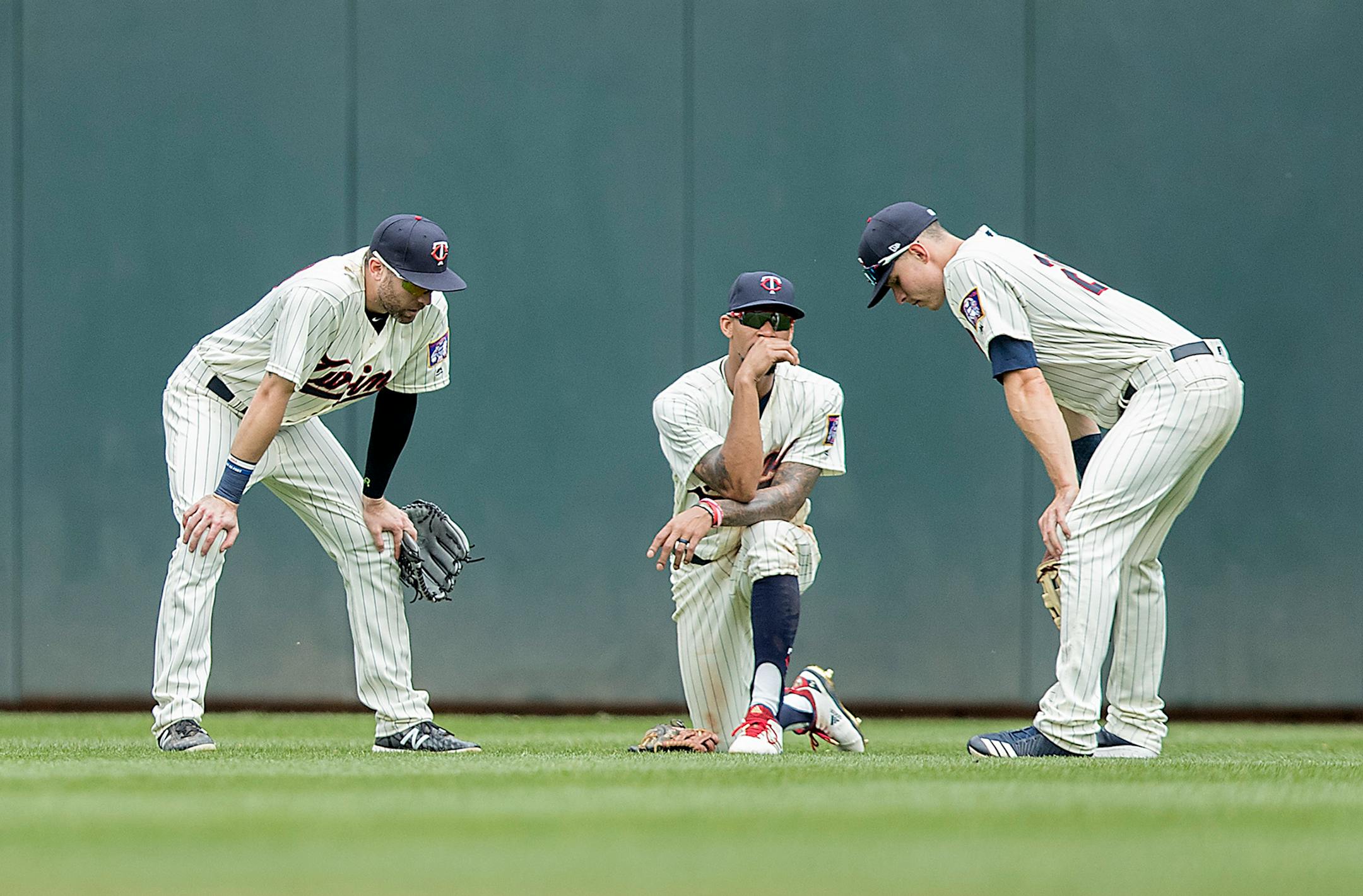 Twins outfielders Jake Cave, left, Byron Buxton, center, and Max Kepler chat during a pitching change during the top of the eighth inning