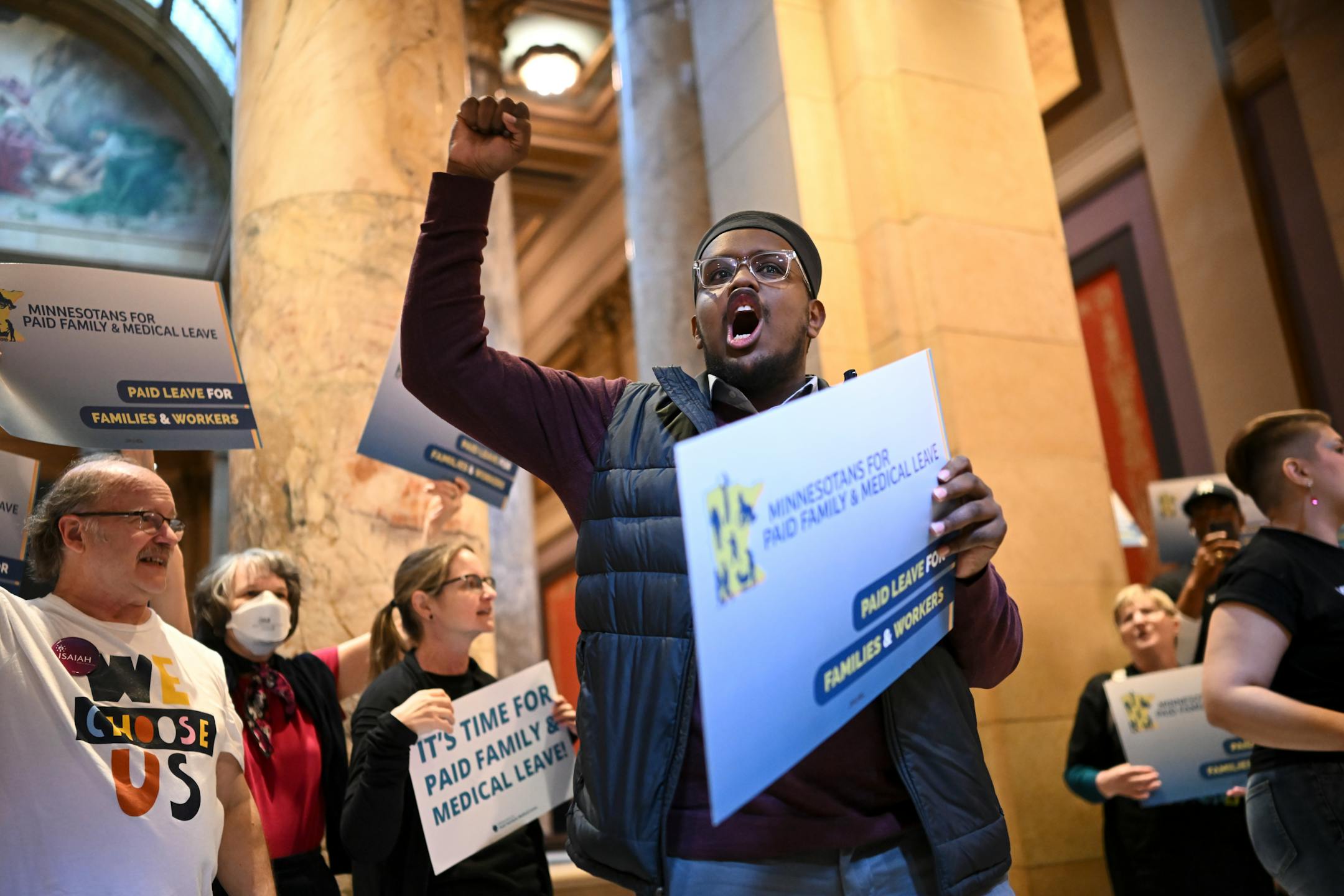 Khalid Omar, right of center, with ISAIAH and Faith in Minnesota, leads a chant in Somali of "Today, today, today is a big day," with paid family leave advocates at the Minnesota State Capitol Monday.