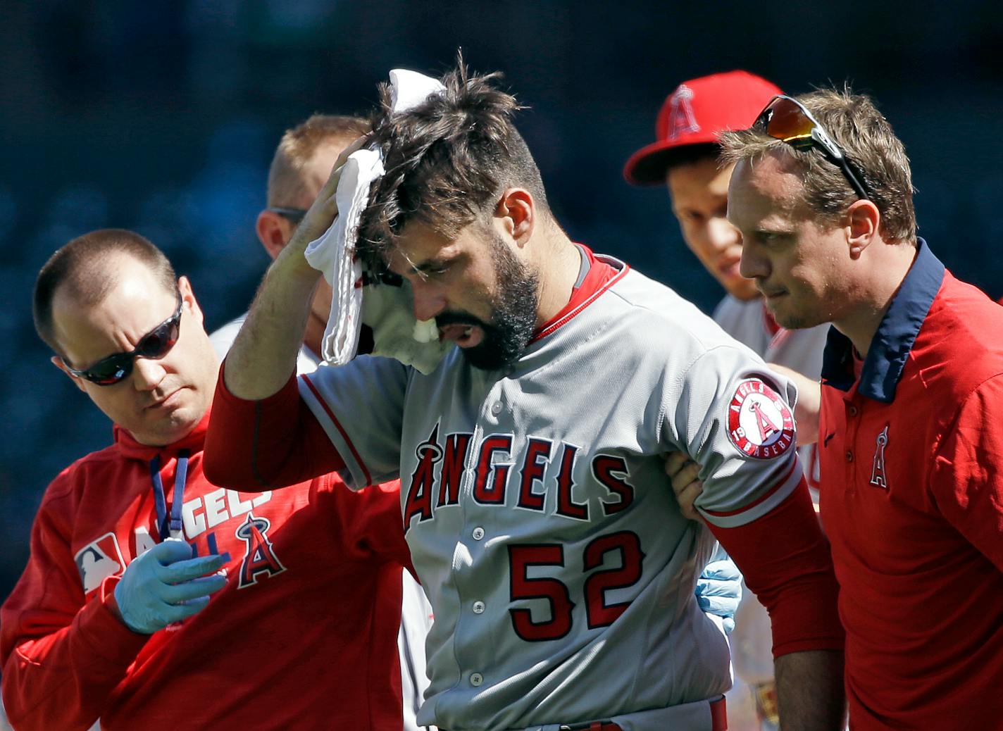 Los Angeles Angels starting pitcher Matt Shoemaker is assisted off the field after being hit by a line drive from Seattle Mariners' Kyle Seager in the second inning of a baseball game, Sunday, Sept. 4, 2016, in Seattle. (AP Photo/Elaine Thompson)