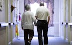 Decima Assise, who has Alzheimer's disease, and Harry Lomping walk the halls, Friday, Nov. 6, 2015, at The Easton Home in Easton, Pa. Nursing homes an