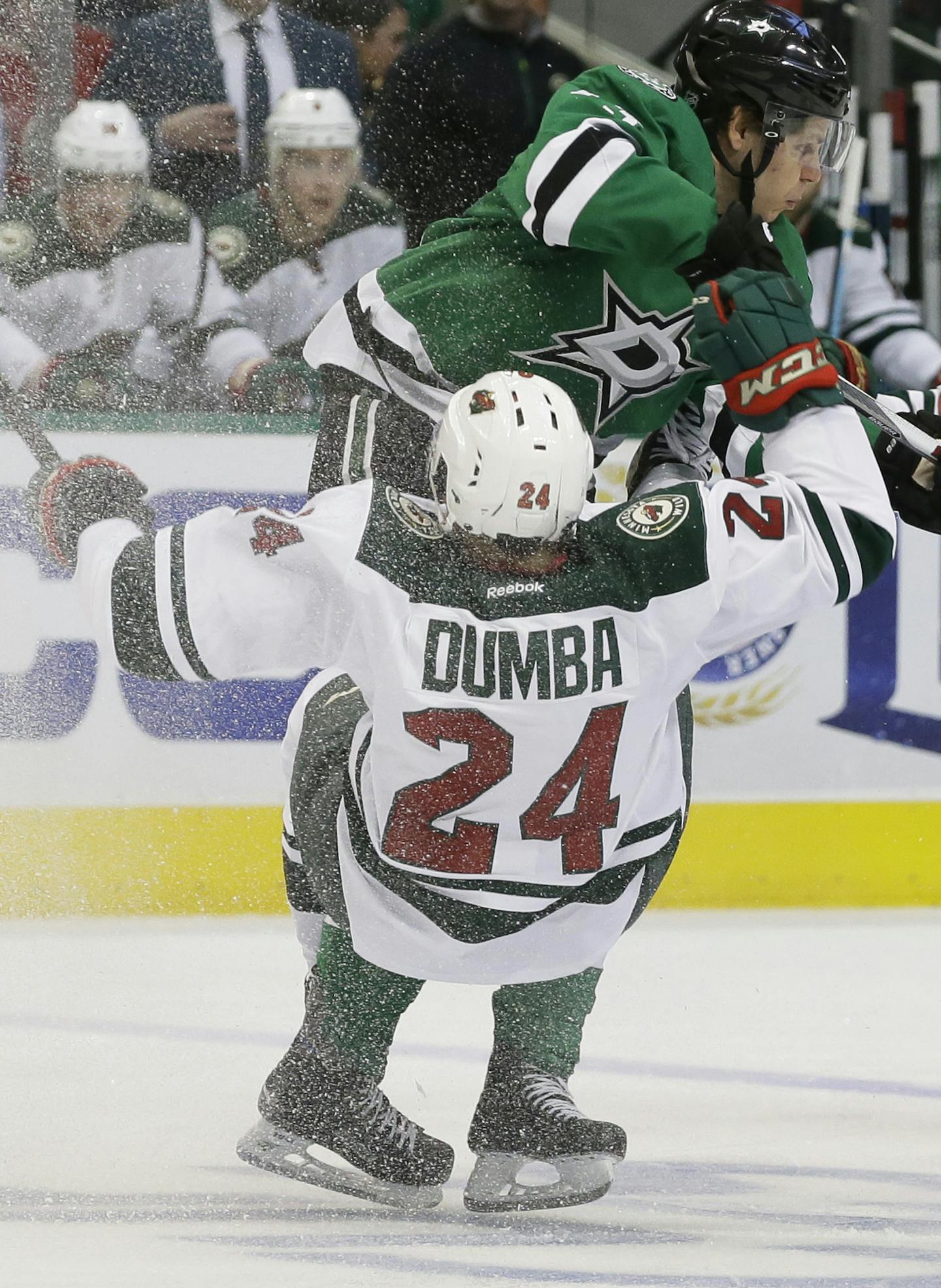 Minnesota Wild defenseman Matt Dumba (24) is knocked off his skates by Dallas Stars center Mattias Janmark during the first period of Game 1 in a first-round NHL hockey Stanley Cup playoff series Thursday, April 14, 2016, in Dallas. (AP Photo/LM Otero) ORG XMIT: DNA106