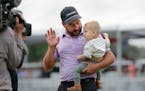 Stephan Jaeger holds son Fritz while trying to get him to wave to TV cameras after his victory in the Houston Open on Sunday.