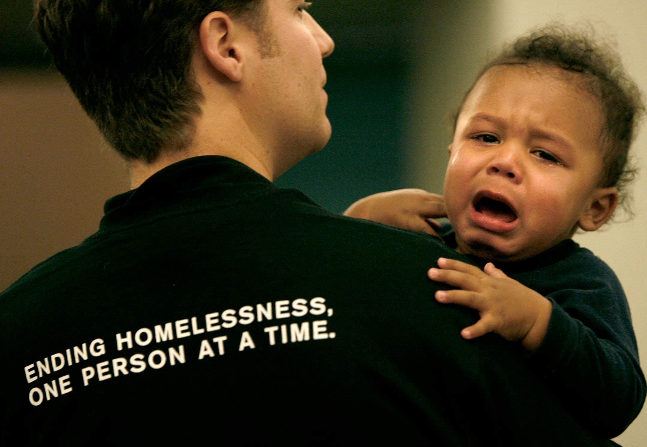 Volunteer Steve Baxter attempted to comfort Tyree Harris, 1, as his mother Bryanne Schultz sought help at the Project Homeless Connect event at the Minneapolis Convention Center.