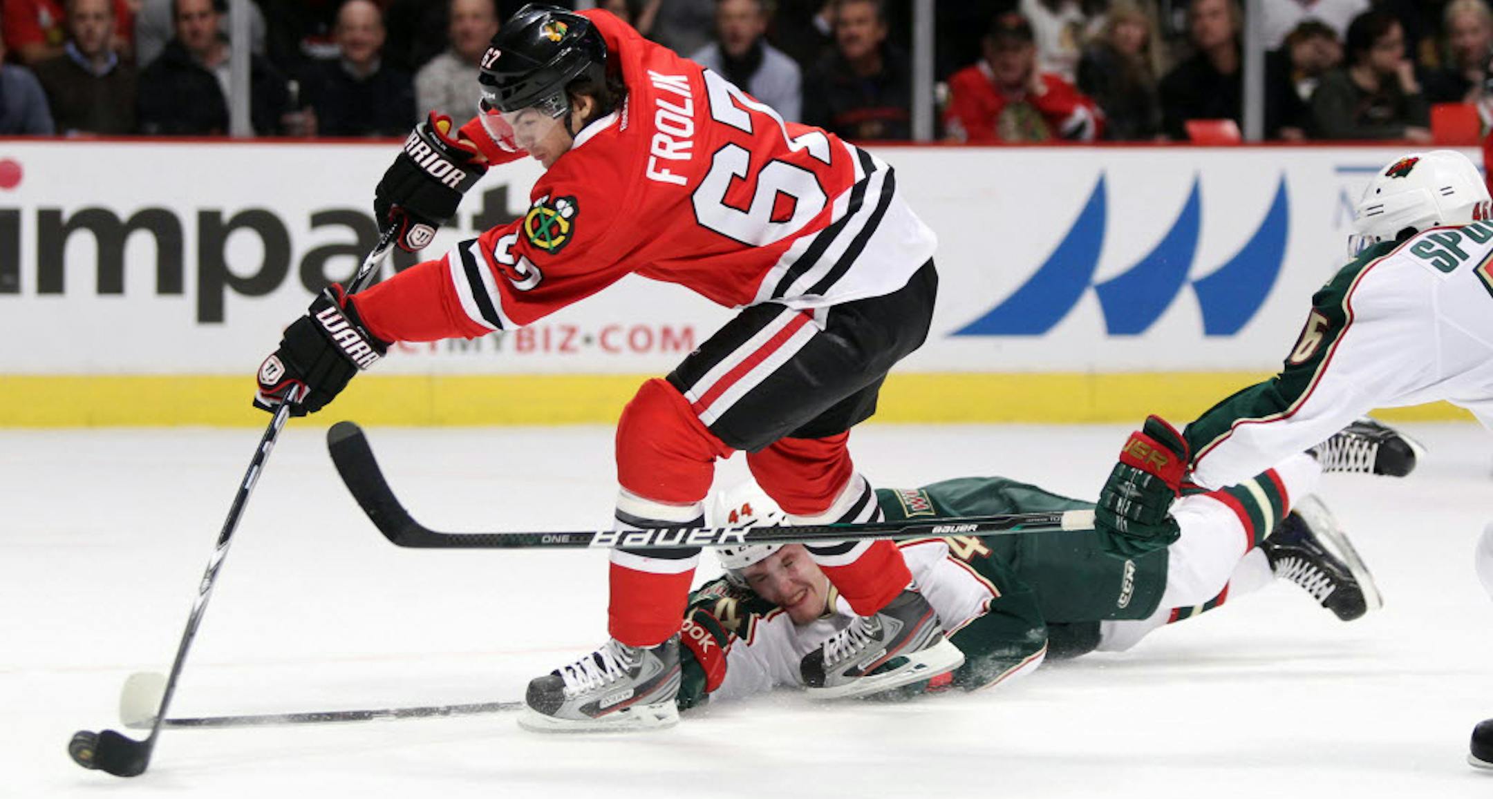 Minnesota's Justin Falk (44) tried to steal the puck from Chicago's Michael Frolik.