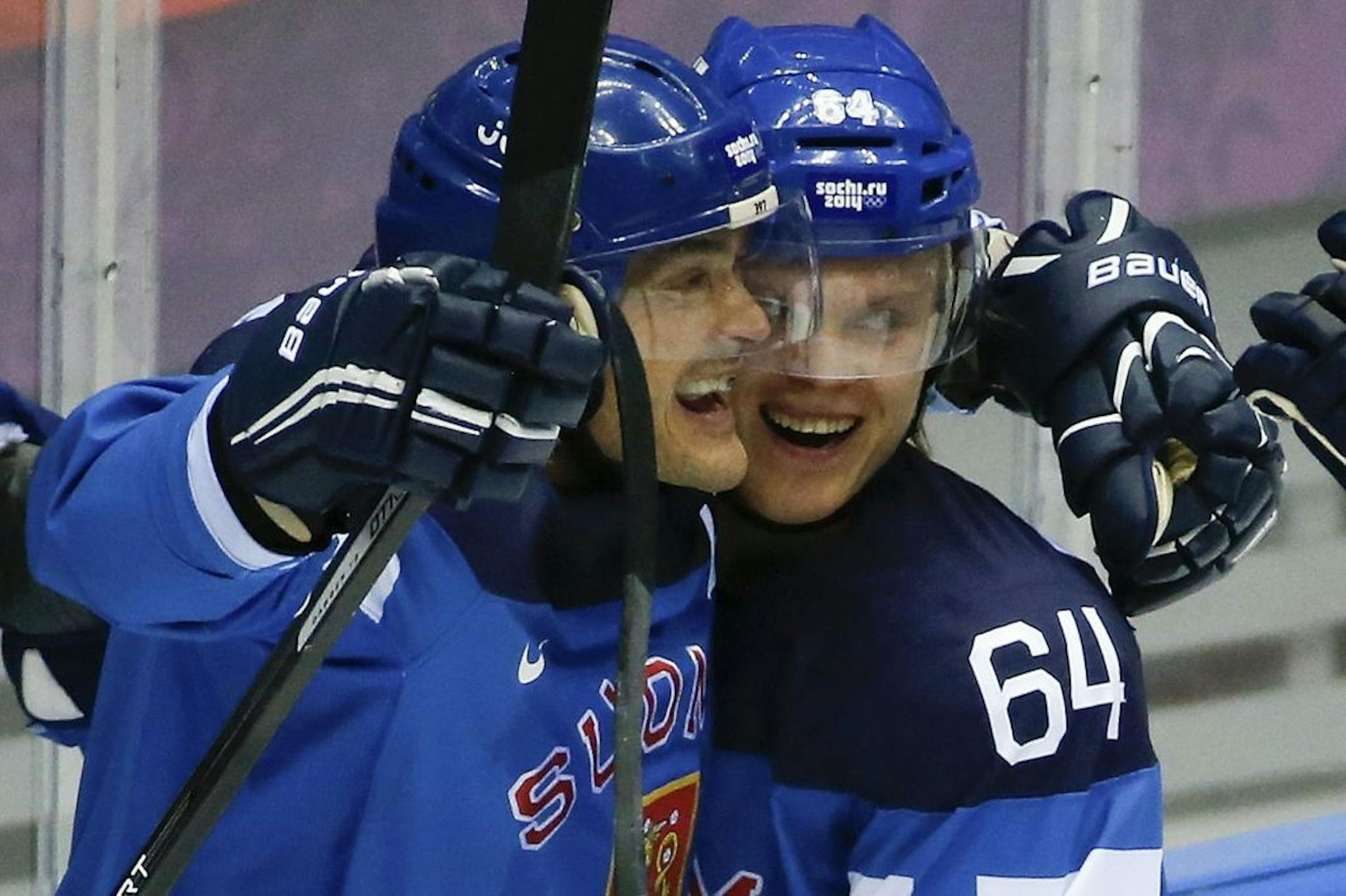 Finland forward Teemu Selanne and Finland forward Mikael Grandlund celebrate a second period goal against Russia during a men's quarterfinal ice hockey game at the 2014 Winter Olympics, Wednesday, Feb. 19, 2014, in Sochi, Russia.