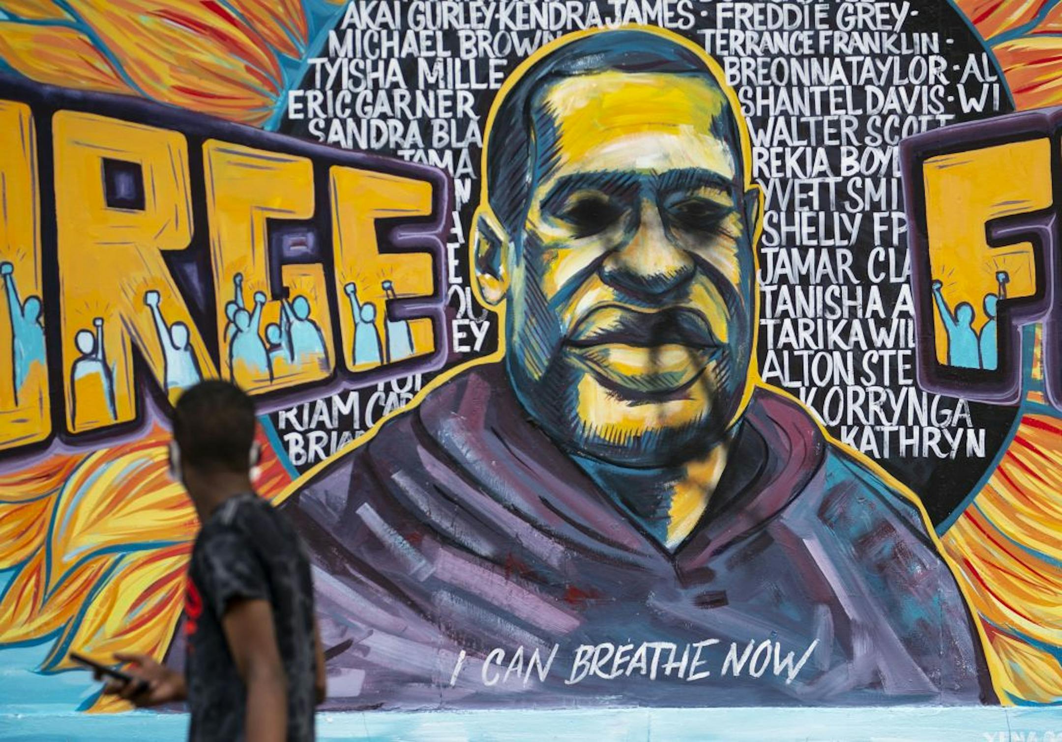 A man walked past the recently defaced George Floyd Mural in Minneapolis onThursday morning.