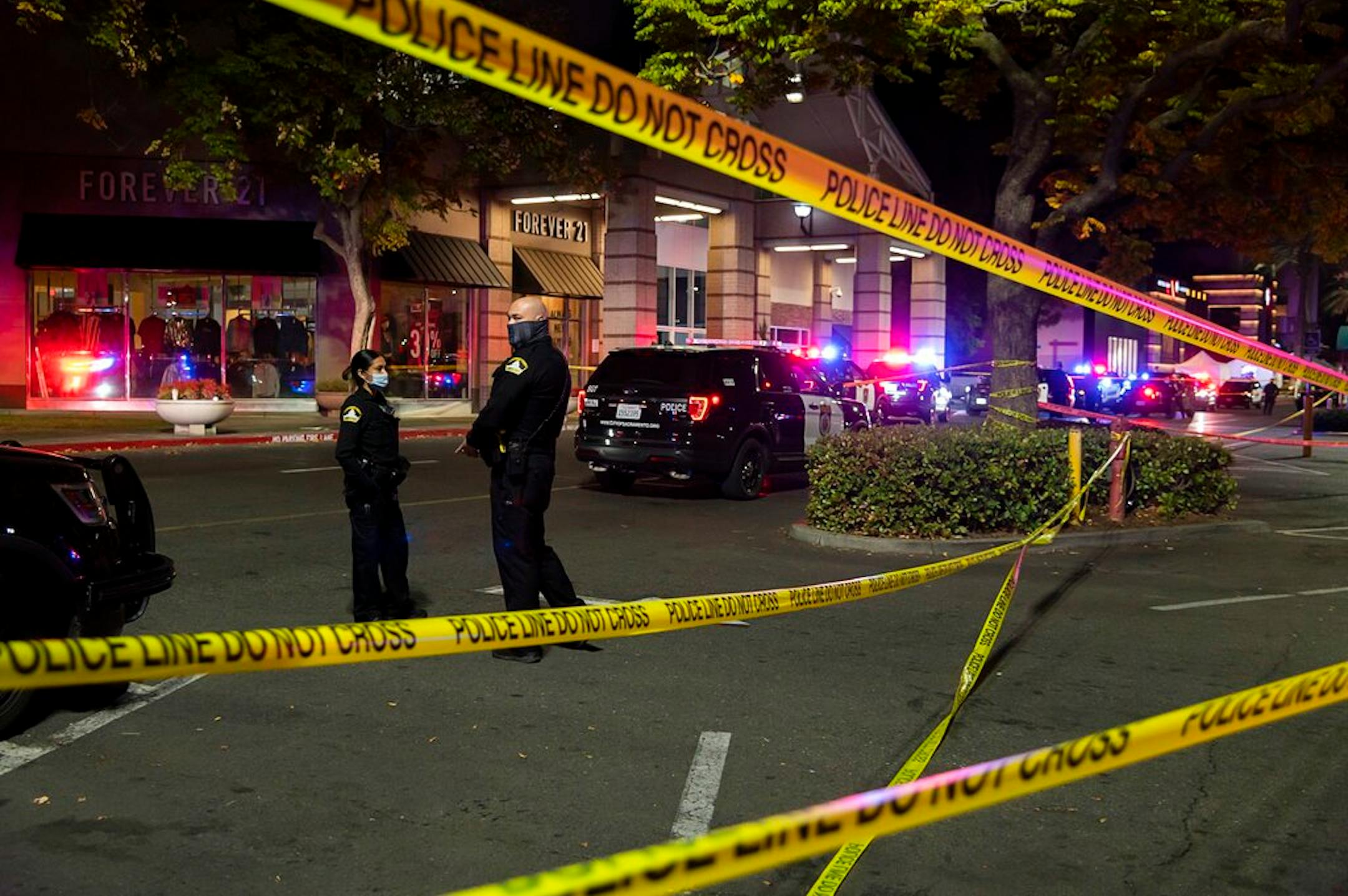 Police stand outside Arden Fair Mall after a shooting that left one person dead and another critically injured, Friday, Nov. 27, 2020, in Sacramento, Calif.