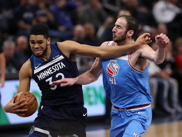 Minnesota Timberwolves center Karl-Anthony Towns (32) held off Sacramento Kings center Kosta Koufos (41), who was fouling him as he drove to the net i
