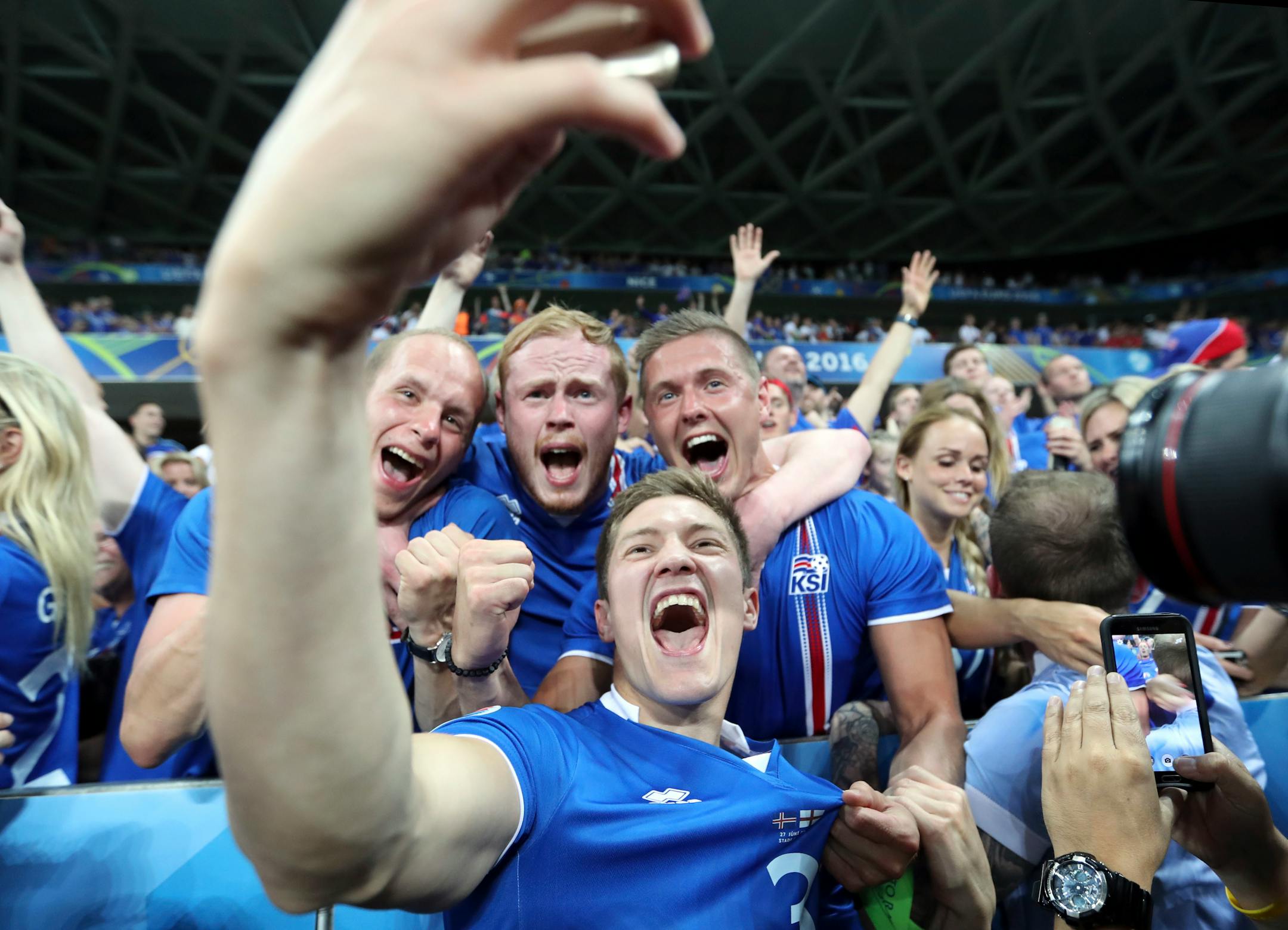 Iceland's Haukur Heidar Hauksson takes a selfie with supporters at the end of the Euro 2016 round of 16 soccer match between England and Iceland, at the Allianz Riviera stadium in Nice, France, Monday, June 27, 2016. (AP Photo/Claude Paris)
