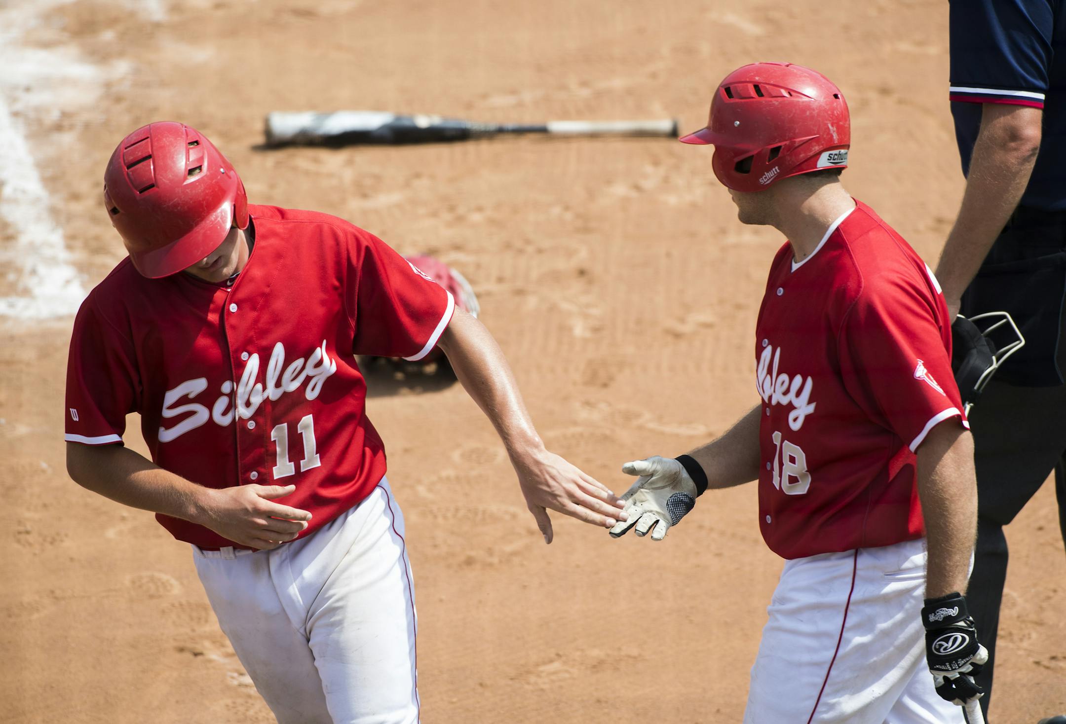 Henry Sibley infielder Max Buell (11) high-fives pitcher Sam Gantman (18) after scoring a run in the first inning to put the Warriors ahead of the Red Knights 1-0. ] Isaac Hale ï isaac.hale@startribune.com The Henry Sibley Warriors defeated Benilde-St. Margaret's Red Knights 4-1 in the Minnesota State High School League 3A semifinals at Siebert Stadium in Minneapolis, MN, on Friday, June 17, 2016.