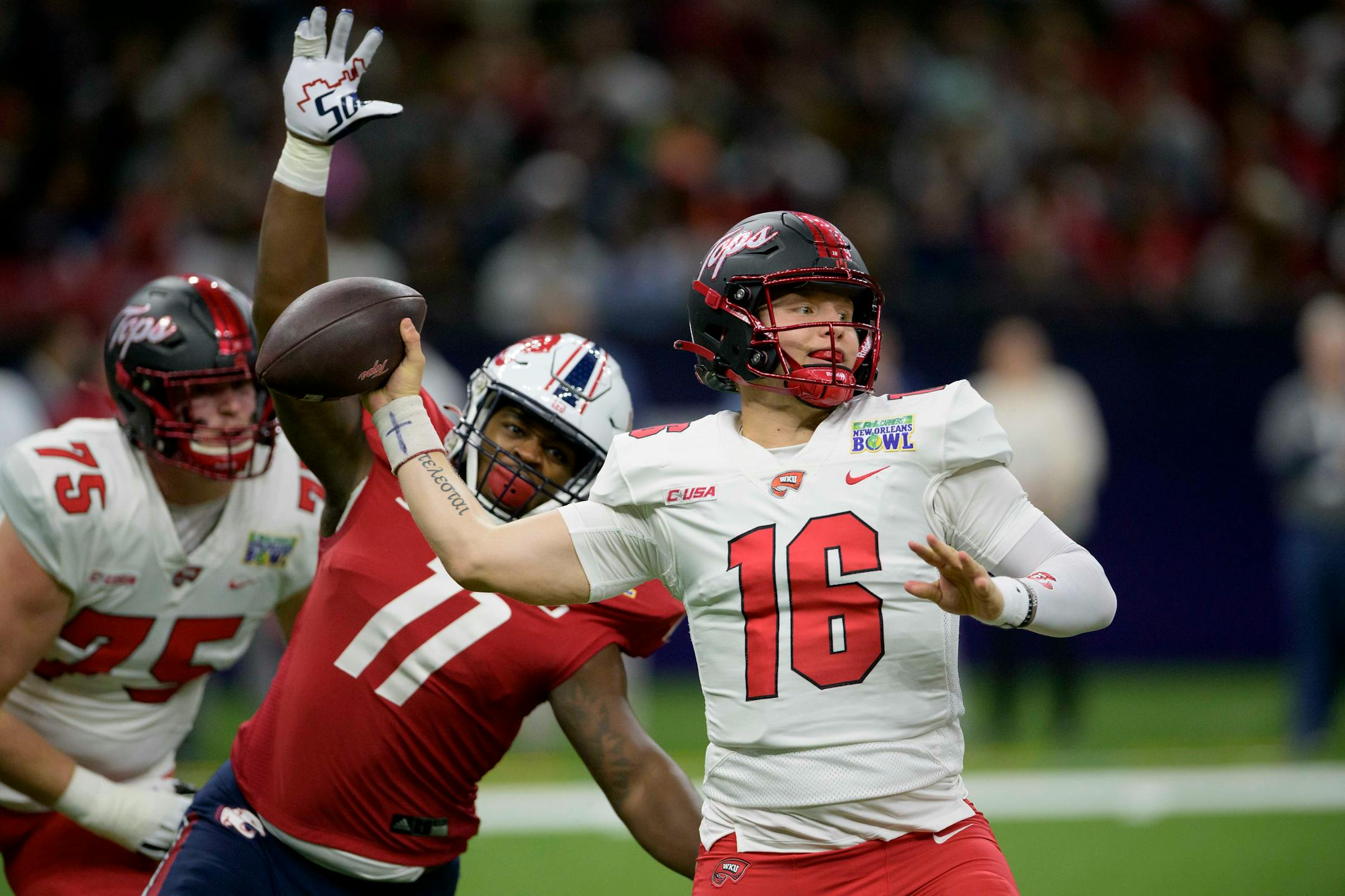 Western Kentucky quarterback Austin Reed throws against South Alabama defensive lineman Jamie Sheriff during the first half of the New Orleans Bowl