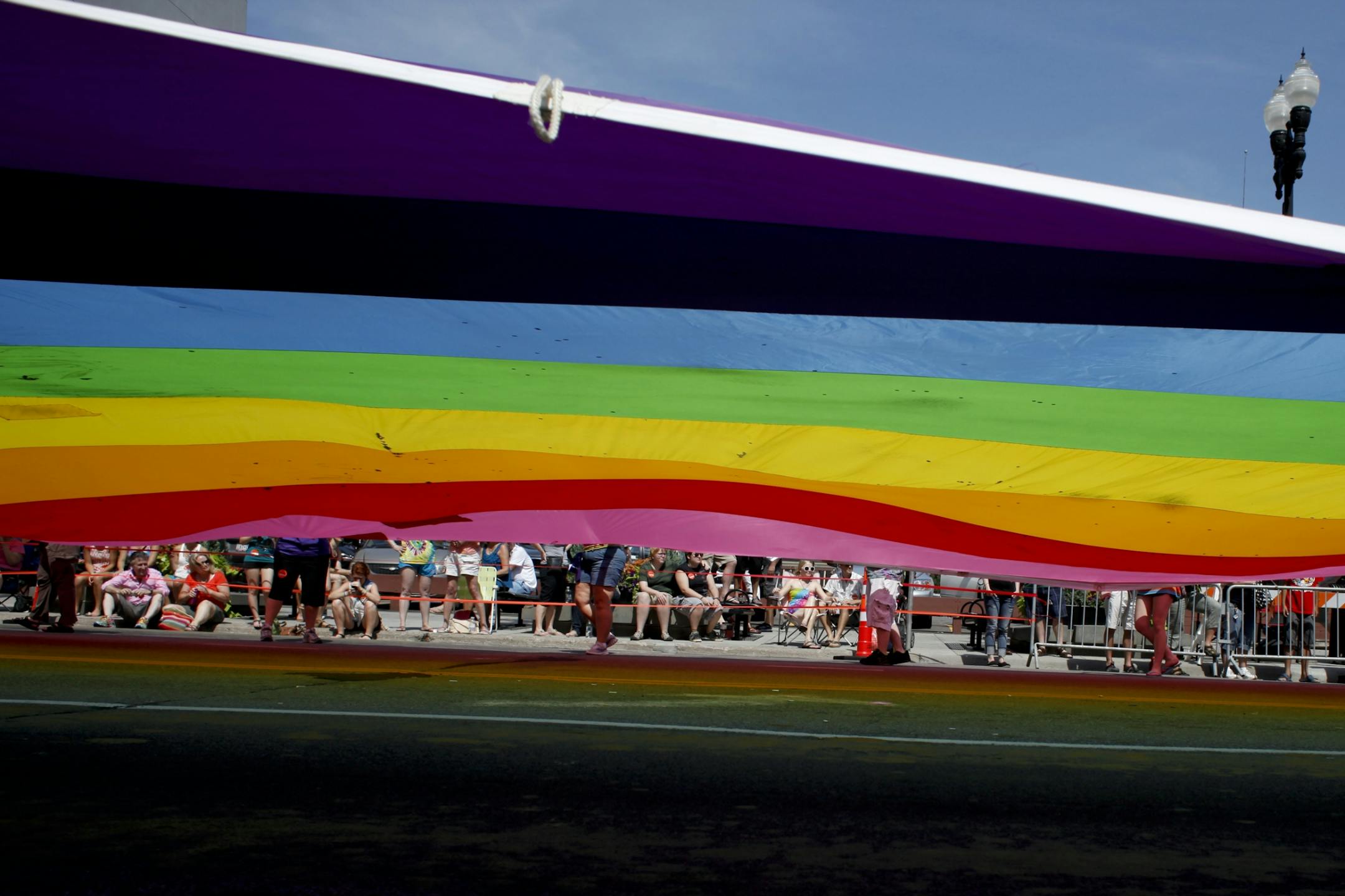 To begin the 2012 Ashley Rukes GLBT Pride Parade a vibrant rainbow parachute leads the way in Minneapolis, Minn. Sunday, June 24, 2012. "It shouldn't matter who's bi or gay," said Walton to Johnson.