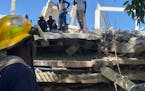 Image taken with a mobile device shows people gather at a damaged building after the earthquake in Les Cayes, Haiti, on Aug. 15, 2021. (Katherine Hern
