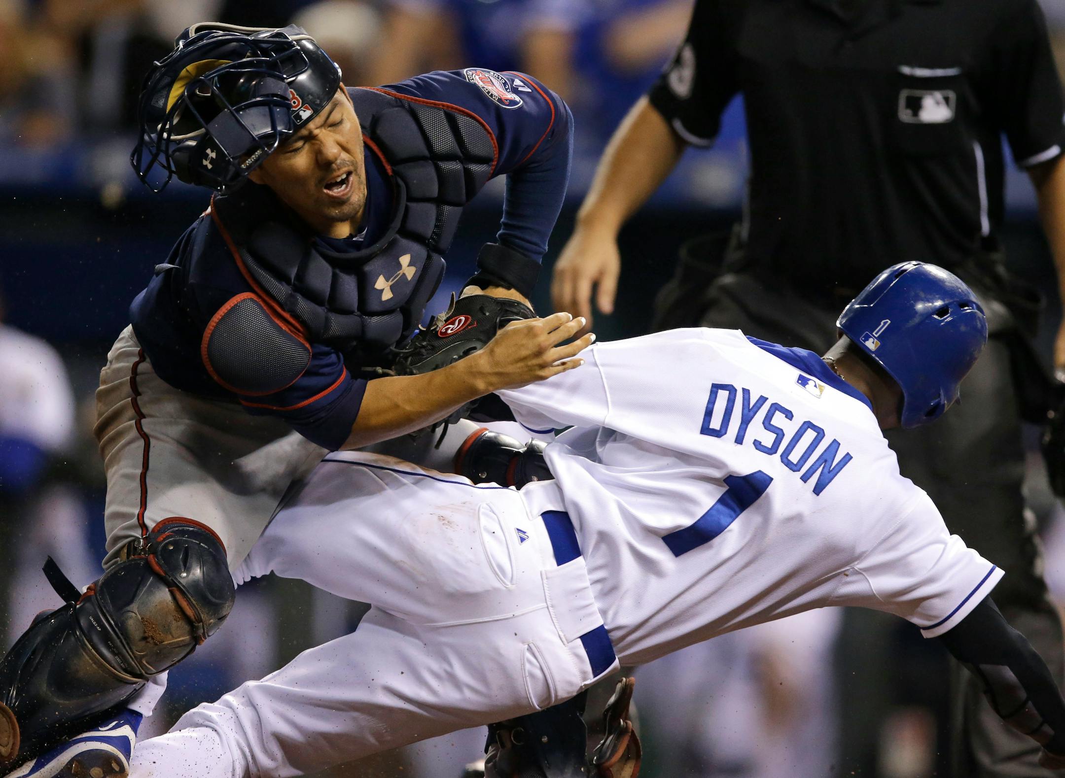 Minnesota Twins catcher Kurt Suzuki, left, tags out Kansas City Royals' Jarrod Dyson (1) during the 10th inning of a baseball game at Kauffman Stadium in Kansas City, Mo., Wednesday, Sept. 9, 2015. Suzuki was injured on the play. (AP Photo/Orlin Wagner)