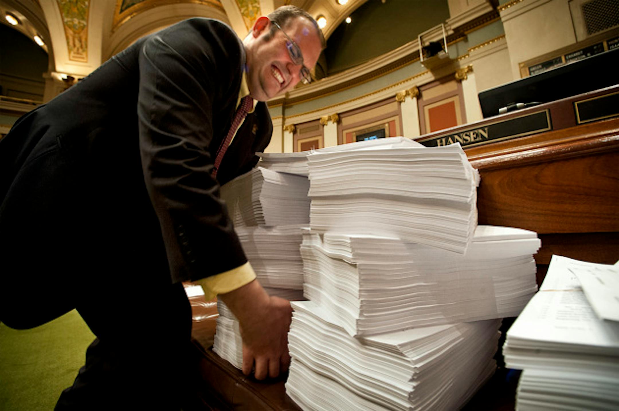 Rep. Dan Schoen, DFL-St. Paul Park, tried to lift a stack of printed proposed amendments to the Health and Human Services Omnibus Finance bill.  The bill has almost 90 amendments, copies of which are stacked on benches to be distributed to members for what is expected to be a long debate.  Monday, April 22, 2013     ]     GLEN STUBBE * gstubbe@startribune.com