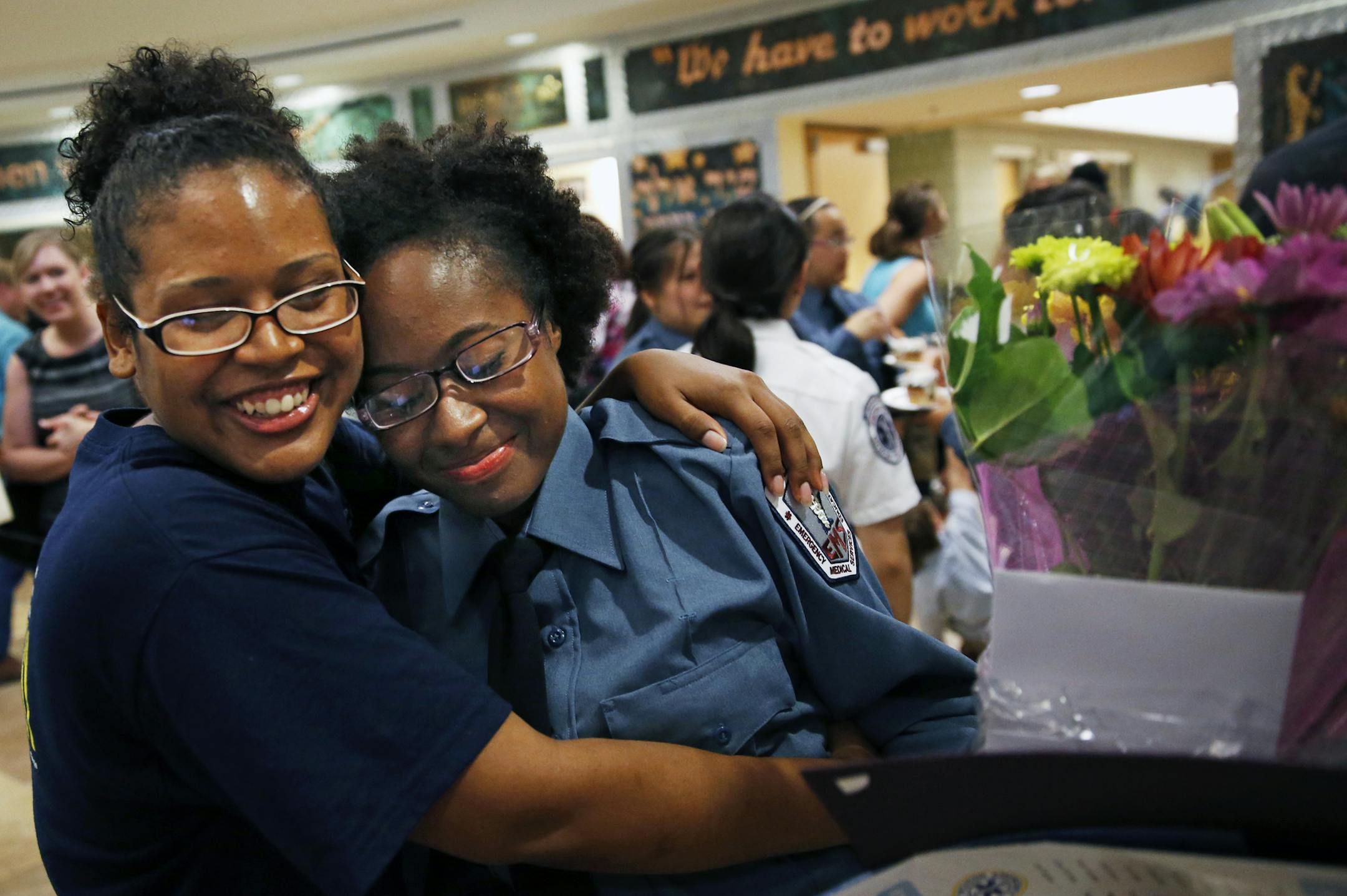 At the Wellstone Center in St. Paul, the Saint Paul EMS Academy graduated 17 EMT's including Kimisha Collins, right who was hugged by a graduate from last year, Tianna Ross.]tsong-taataarii@startribune.com