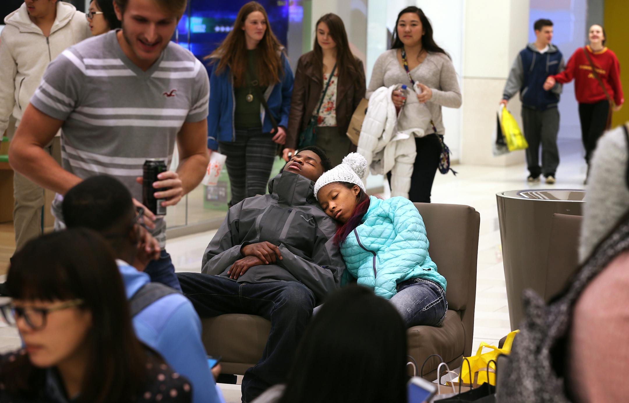 Tiyana Jordan, 14, of Columbia Heights, and Curtis Fortune, 18, of St. Louis Park take a nap together on Black Friday at Mall of America in Bloomington in the early morning on Friday, November 28, 2014. They had been shopping since midnight the night before. ] LEILA NAVIDI leila.navidi@startribune.com /
