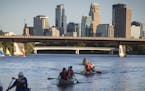 A line of canoes paddled past the audience during the during a rehearsal for the Mississippi River Boat Ballet on the Mississippi River in Minneapolis