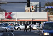 Pedestrians cross the street as cars exit the parking lot of the Kmart on Lake Street and Nicollet Avenue Minneapolis on Thursday, November 5, 2015. ]