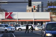 Pedestrians cross the street as cars exit the parking lot of the Kmart on Lake Street and Nicollet Avenue Minneapolis on Thursday, November 5, 2015. ]