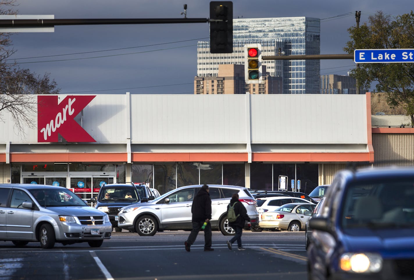 Pedestrians cross the street as cars exit the parking lot of the Kmart on Lake Street and Nicollet Avenue Minneapolis on Thursday, November 5, 2015. ] (LEILA NAVIDI/STAR TRIBUNE) leila.navidi@startribune.com BACKGROUND INFORMATION: The city will announce Thursday that they are poised to buy two parcels of land that comprise the so-called "Kmart site" on Lake Street. The announcement comes more than 15 years after the city began seriously talking about reopening the corridor, a process that has b