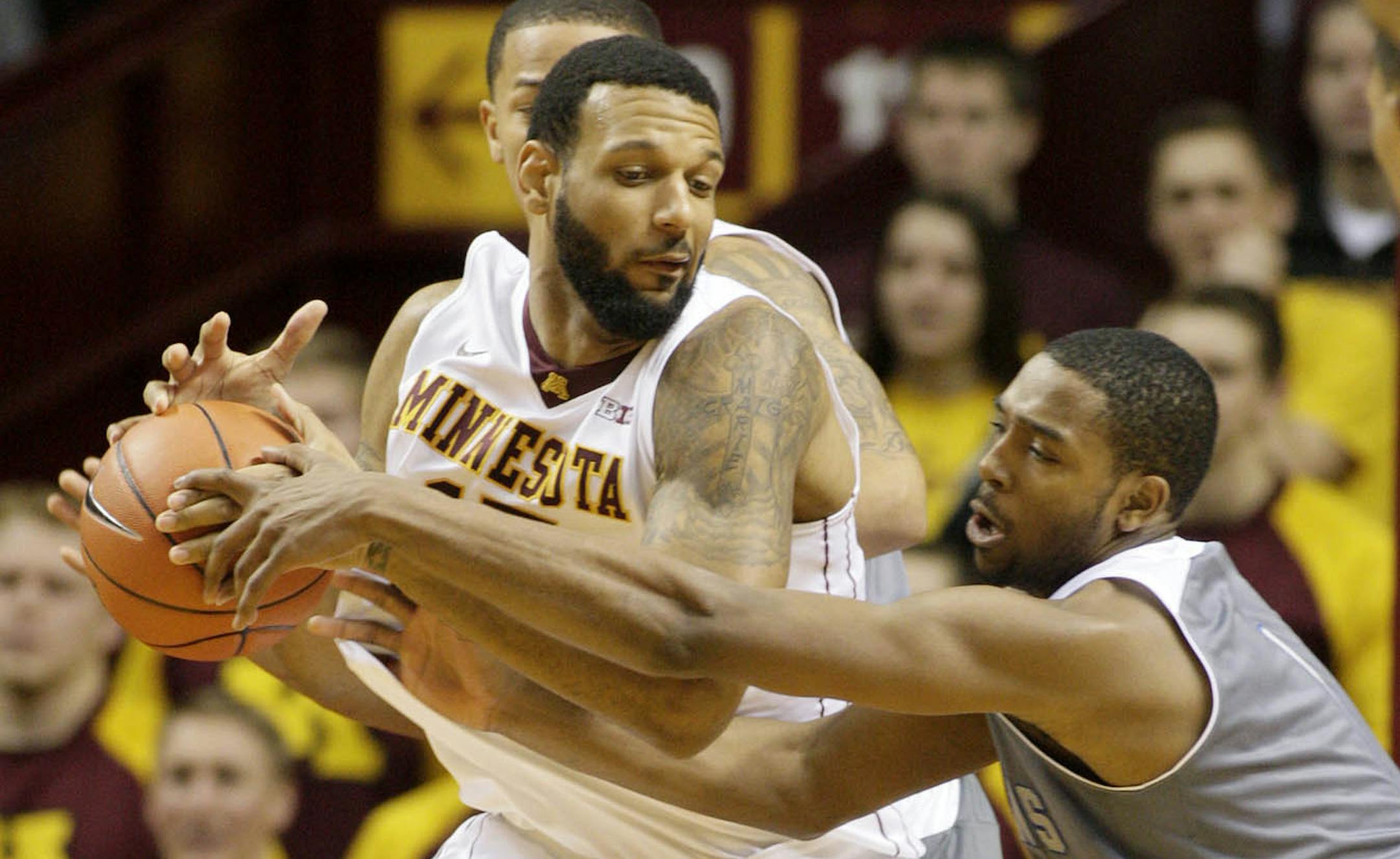 Minnesota forward Maurice Walker, left, is tied-up by New Orleans guard Tevin Broyles (1) during the first half of an NCAA college basketball game, Saturday, Dec. 7, 2013, in Minneapolis. Minnesota won 80-65. (AP Photo/Paul Battaglia) ORG XMIT: MIN2013120717353236