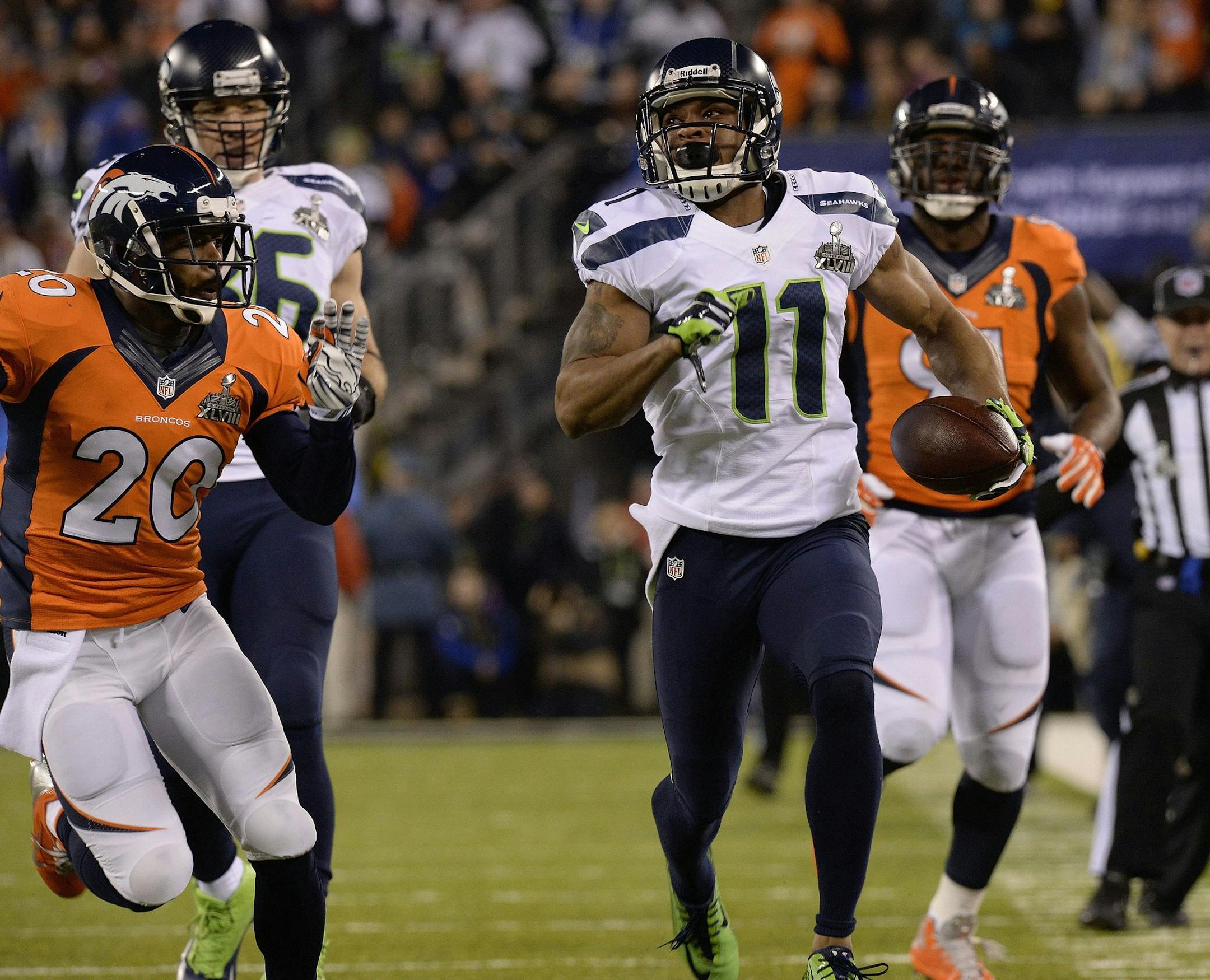 Seattle Seahawks wide receiver Percy Harvin (11) runs down field past Denver Broncos safety Mike Adams for a first down in the first quarter of Super Bowl XLVIII at MetLife Stadium in East Rutherford, N.J., on Sunday, Feb. 2, 2014. (Christian Murdock/Colorado Springs Gazette/MCT)