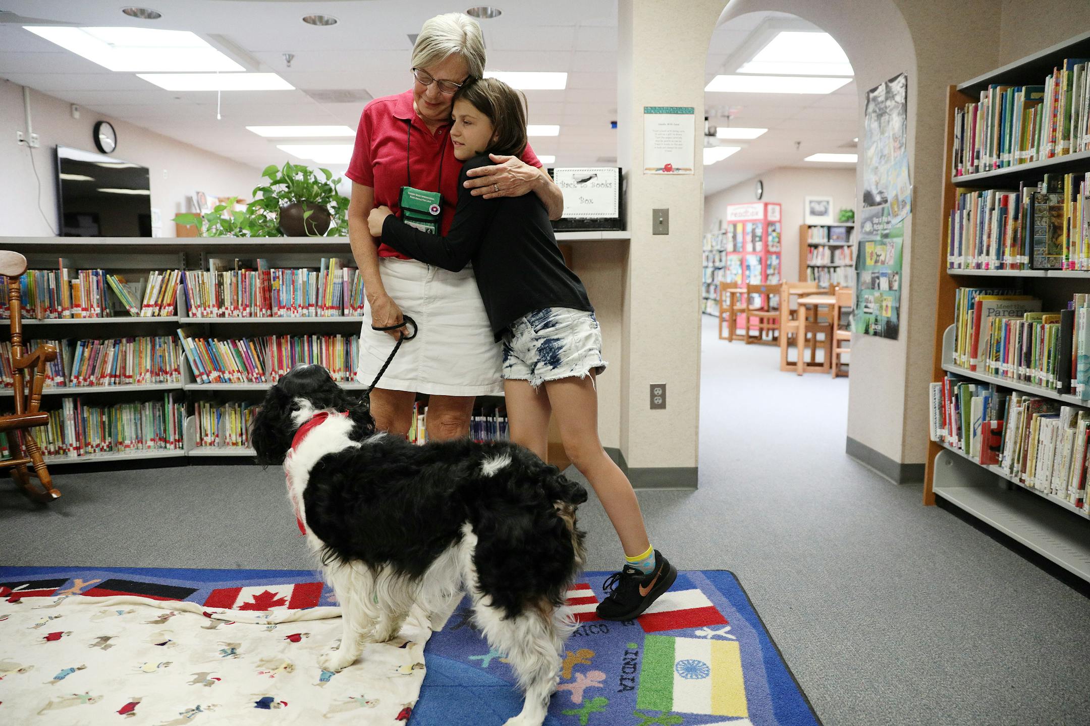 Jan Rempher and her therapy dog Arthur, a 5-year-old English Springer Spaniel, got hugs from Layla Larsen, 9, a fourth grader at Sioux Trail Elementary School after they read together Tuesday.] ANTHONY SOUFFLE • anthony.souffle@startribune.com