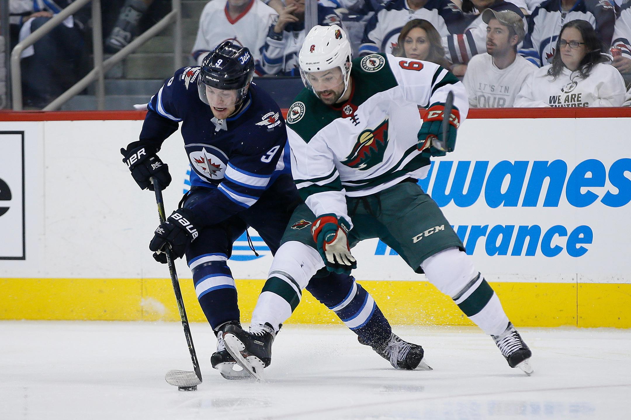 Winnipeg Jets' Andrew Copp (9) steals the puck from Minnesota Wild's Ryan Murphy (6) during the second period in Game 5 of an NHL hockey first-round playoff series in Winnipeg, Manitoba, Friday, April 20, 2018. (John Woods/The Canadian Press via AP)