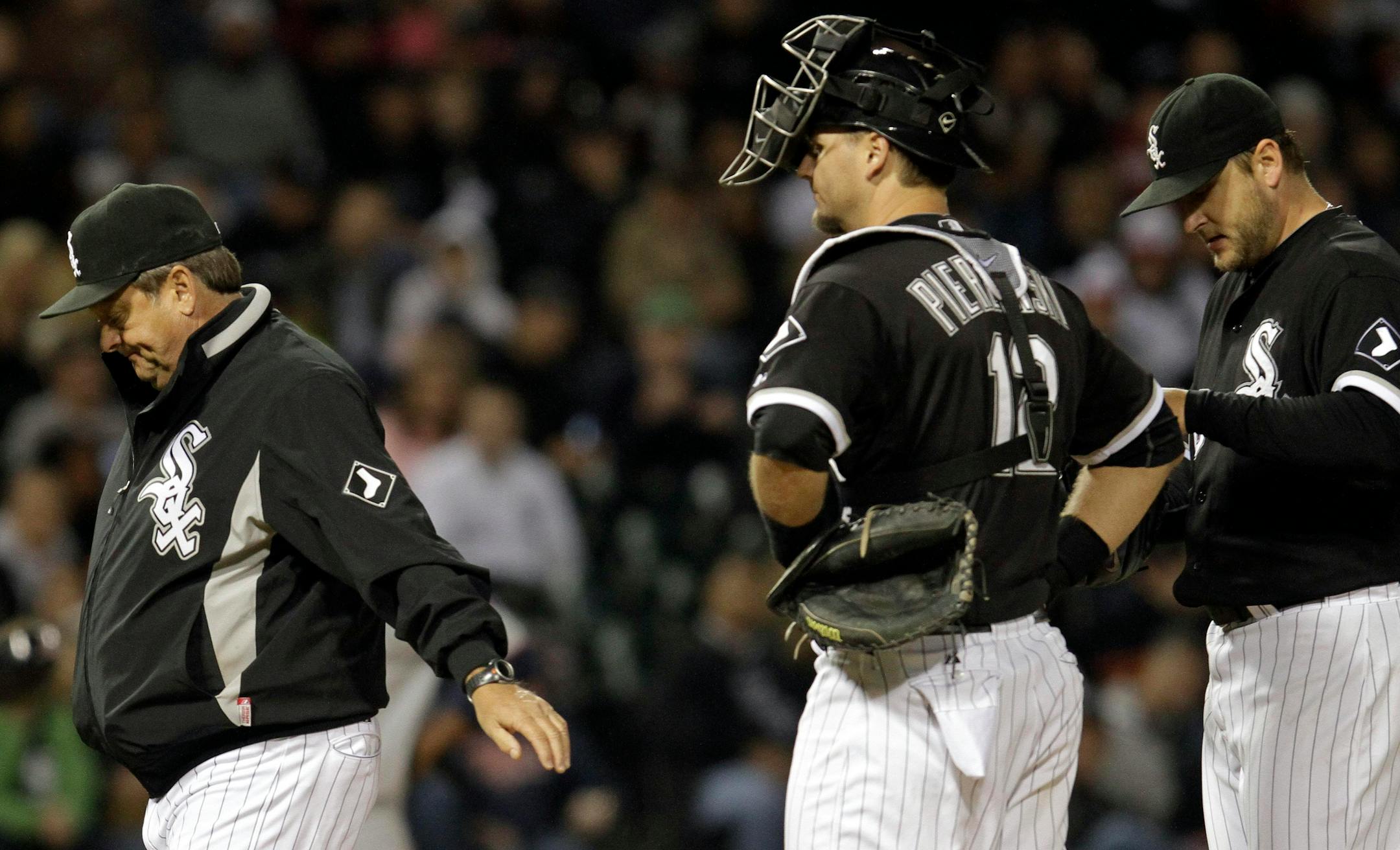 ** CORRECTS SPELLING TO PIERZYNSKI ** Chicago White Sox pitching coach Don Cooper, left, walks to the dugout after talking with starter Mark Buehrle, right, and catcher A.J. Pierzynski during the fifth inning of a baseball game against the Minnesota Twins in Chicago, Thursday, Sept. 16, 2010. (AP Photo/Nam Y. Huh)
