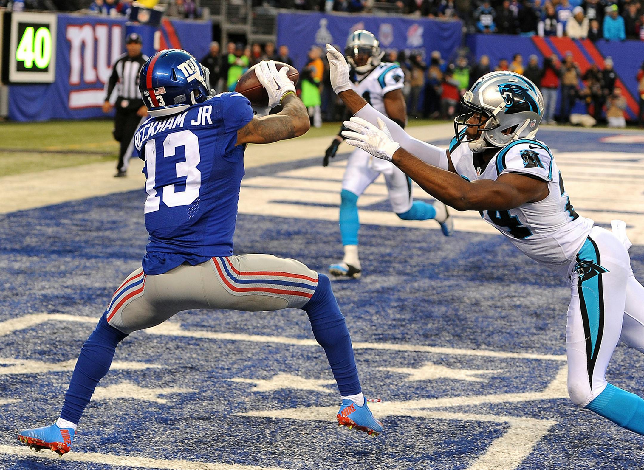 New York Giants wide receiver Odell Beckham, Jr. (13) catches a touchdown pass from quarterback Eli Manning during fourth-quarter action as Carolina Panthers cornerback Josh Norman, right, applies pressure at MetLife Stadium in East Rutherford, N.J., on Sunday, Dec. 20, 2015. The Panthers won, 38-35. (Jeff Siner/Charlotte Observer/TNS)