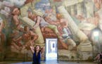 A visitor stares in amazement at Giulio Romano�s 1534 fresco in the Hall of the Giants at the Palazzo Te in Mantua, Italy.�