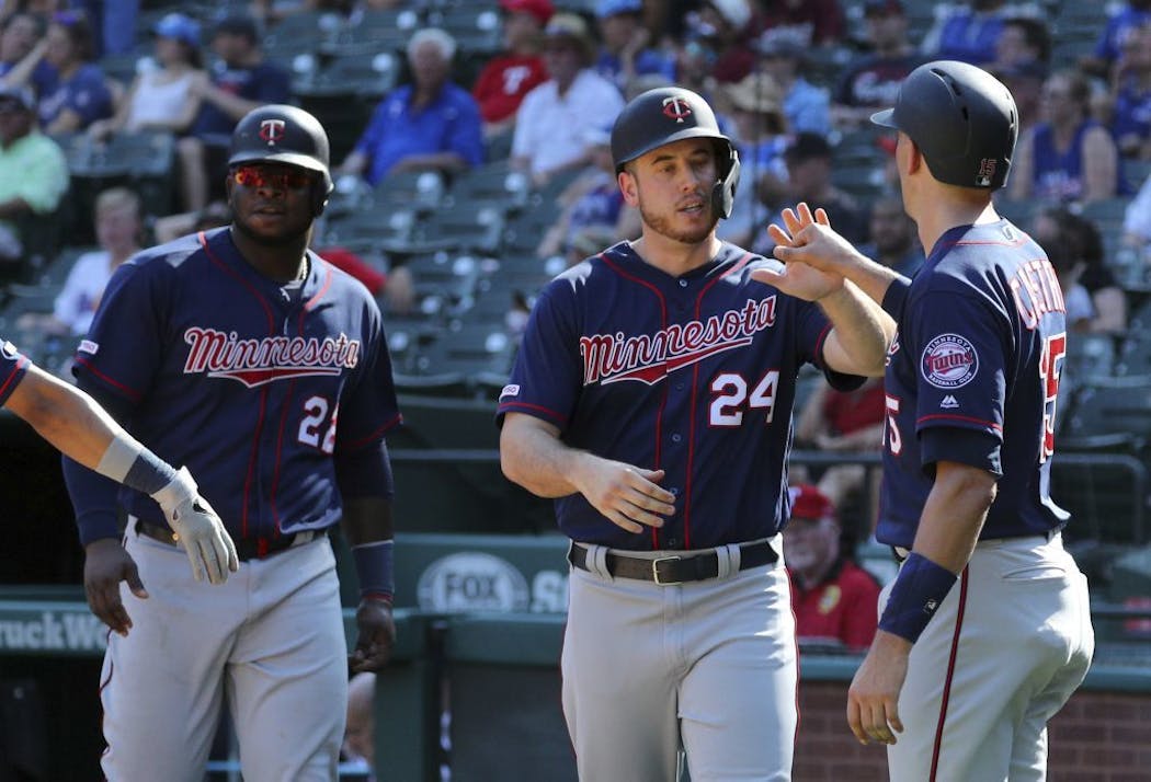 Minnesota Twins Miguel Sano (22), C.J. Cron (24) and Jason Castro (15) celebrate after scoring on a triple by Jorge Polanco in the eighth inning.