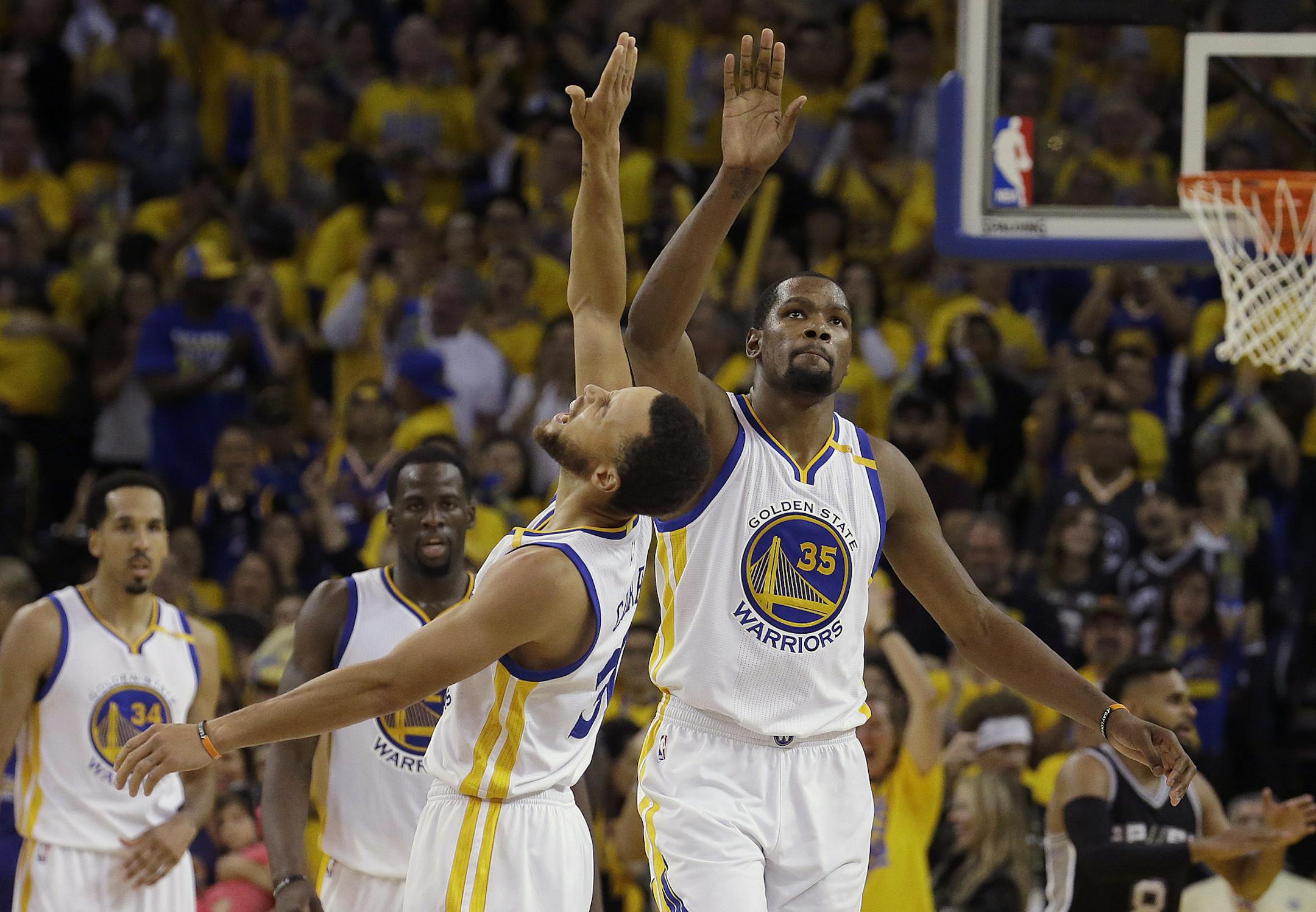 Golden State Warriors guard Stephen Curry, center left, and forward Kevin Durant (35) celebrate during the second half of Game 1 of the NBA basketball Western Conference finals against the San Antonio Spurs in Oakland, Calif., Sunday, May 14, 2017. (AP Photo/Jeff Chiu)