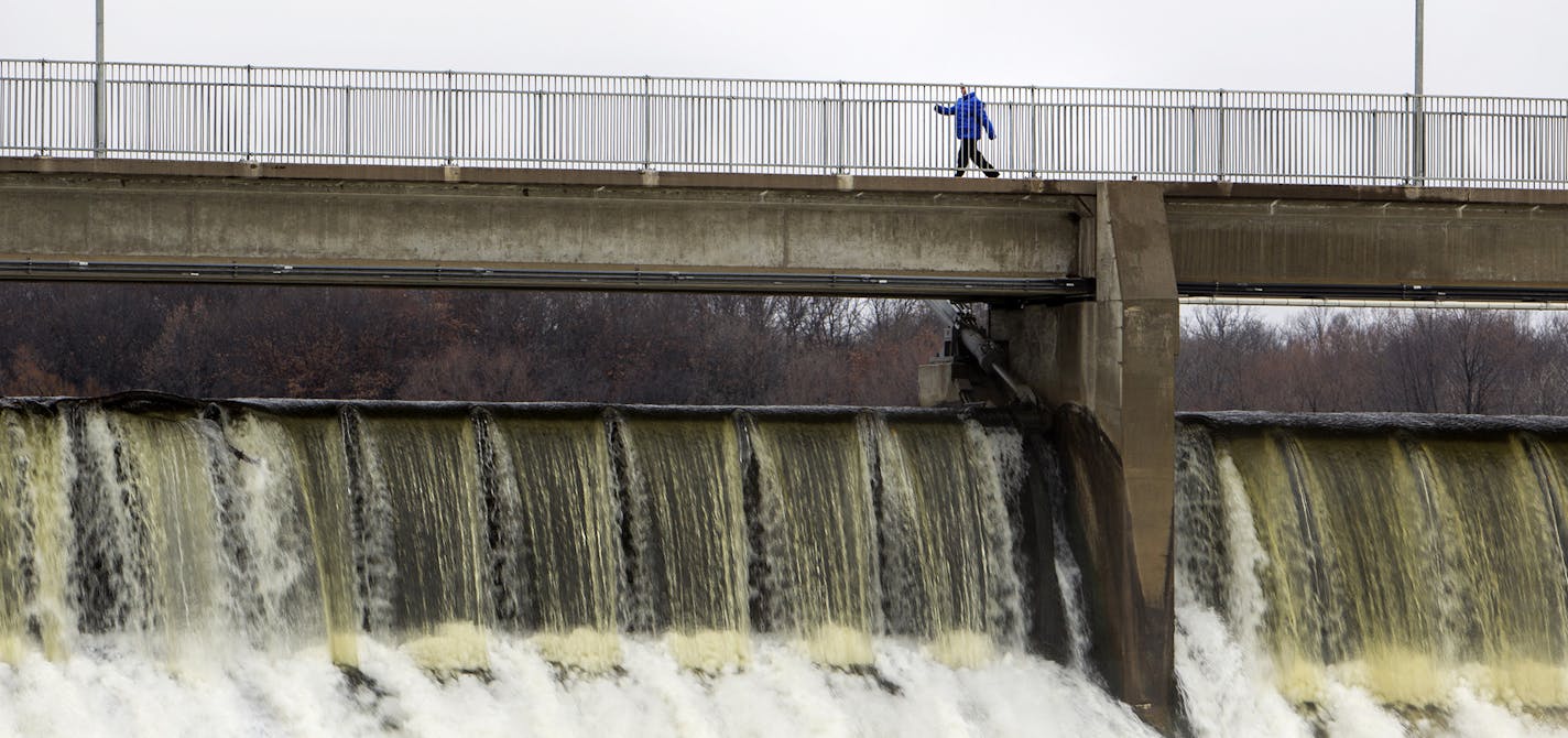 A pedestrian walks across a bridge over the Coon Rapids Dam connecting Coon Rapids Dam Regional Park and Anoka County park property November 12, 2015. Coon Rapids Dam Regional Park, which is part of the Three Rivers Park District and located in Brooklyn Park, MN, will soon be changing its name as part of a large makeover. (Courtney Perry/Special to the Star Tribune)