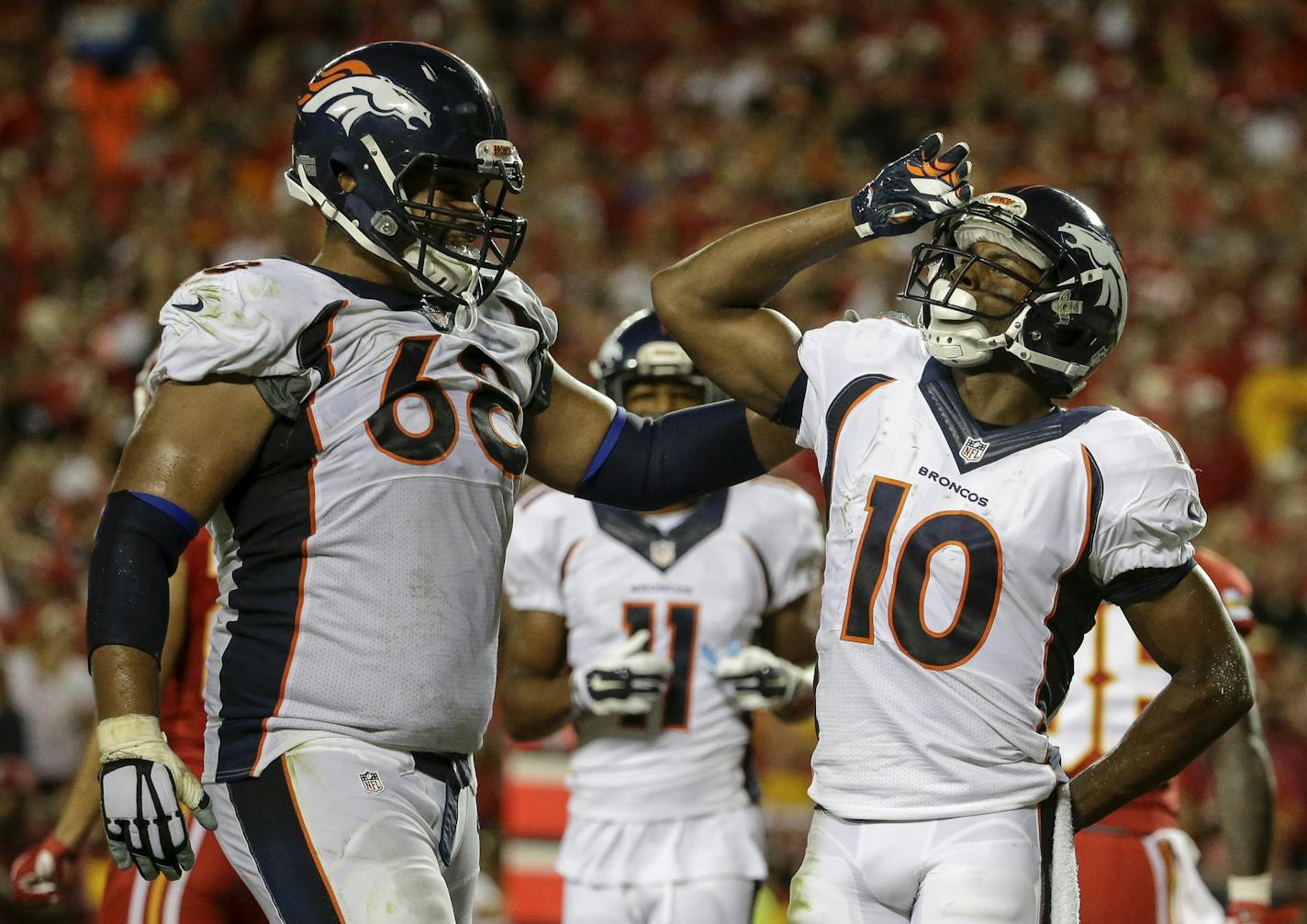 Denver Broncos wide receiver Emmanuel Sanders (10) salutes with offensive tackle Ryan Harris (68) by his side after he scored a touchdown against the Kansas City Chiefs during the first half of an NFL football game in Kansas City, Mo., Thursday, Sept. 17, 2015. (AP Photo/Charlie Riedel)