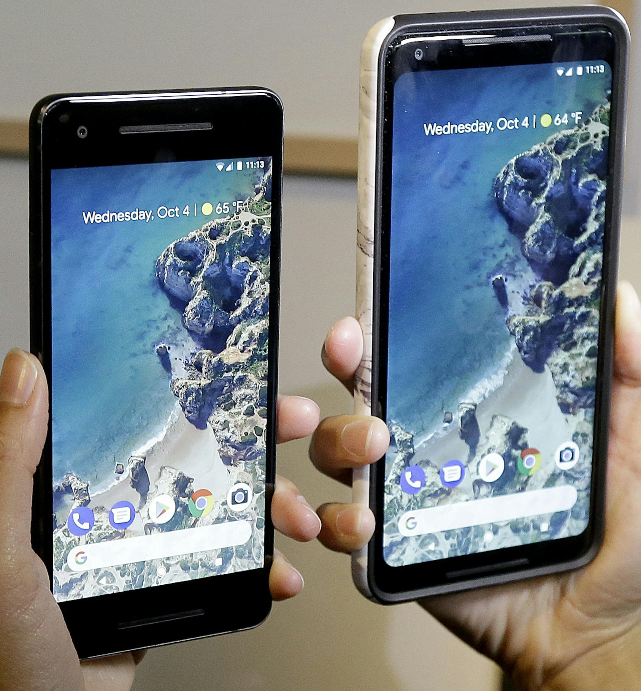 FILE - In this Wednesday, Oct. 4, 2017, file photo, a woman holds up the Google Pixel 2 phone, left, next to the Pixel 2 XL phone at a Google event at the SFJAZZ Center in San Francisco. The phones set themselves apart with promises to bake in Google&#xed;s powerful artificial-intelligence technology for quick and easy access to useful, even essential information. You get some of that right away, but more will come later through free software updates and a wireless accessory. (AP Photo/Jeff Chiu