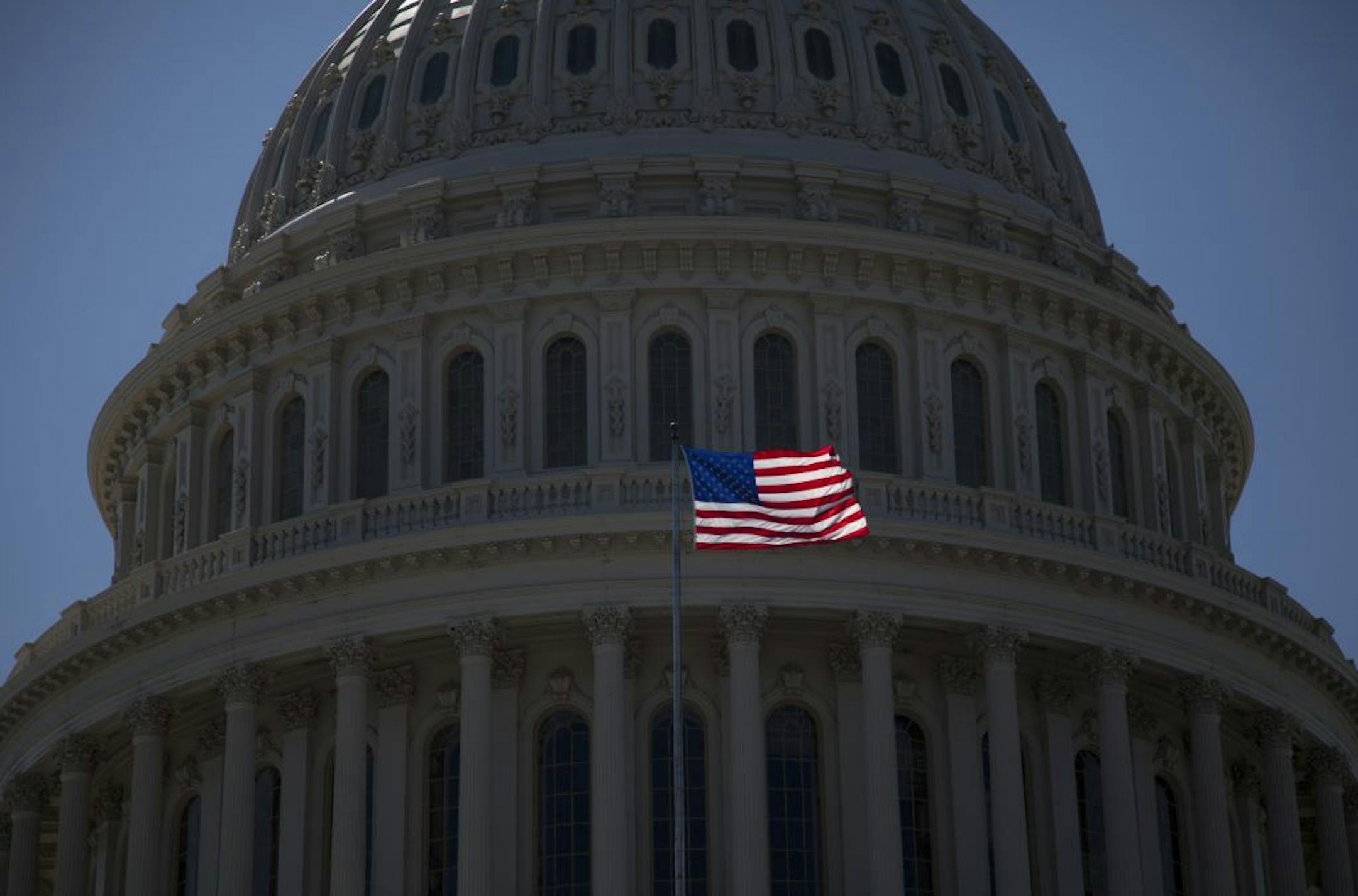An American Flag is seen flying in the sun in front of the dome of the United States Capitol building, Tuesday, July 26, 2011, in Washington.