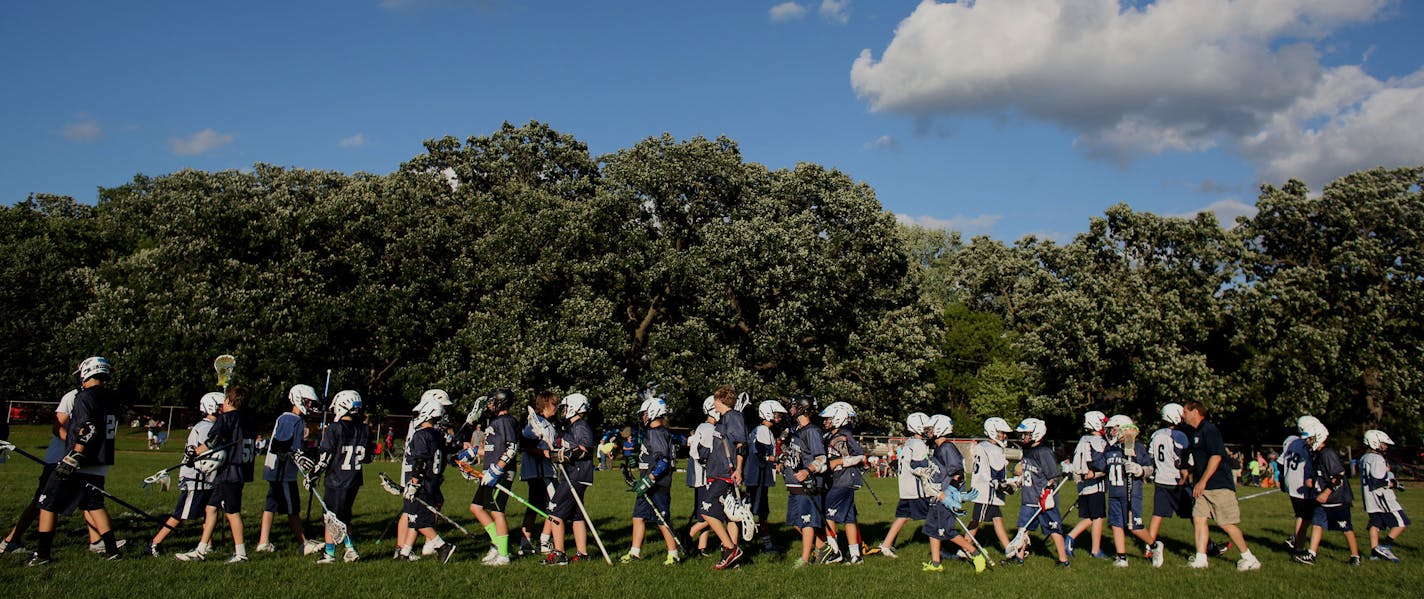 Saint Paul and Hudson shake hands after U13 lacrosse game. ] (KYNDELL HARKNESS/STAR TRIBUNE) kyndell.harkness@startribune.com St Paul Lacrosse team vs Hudson at Murray Field in St. Paul, Min. Tuesday, July 8, 2014. The St. Paul Lacrosse Association s building a program that has produced more than two dozen college players. We look at the association, and fledging efforts by St. Paul Parks and Recreation, to build lacrosse in the city... for city kids.