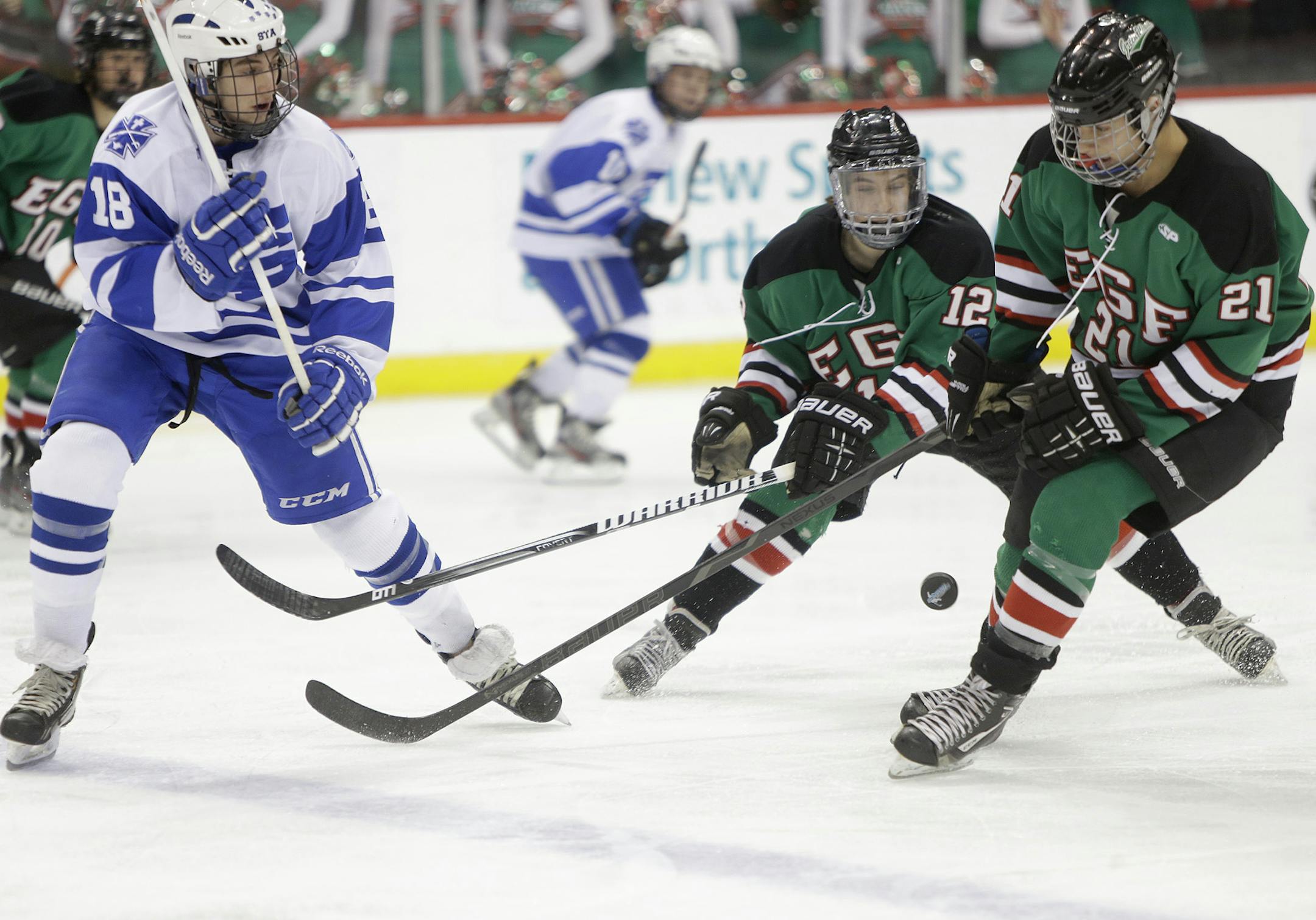 St. Thomas Academy's Austin Sattler and East Grand Forks' Tye Ausmus and Rayce Martin battled for the puck during the first period of the Class 1A boys' hockey state tournament semifinals at the Xcel Energy Center, Thursday, March 8, 2013 in St. Paul, MN.(ELIZABETH FLORES/STAR TRIBUNE) ELIZABETH FLORES • eflores@startribune.com