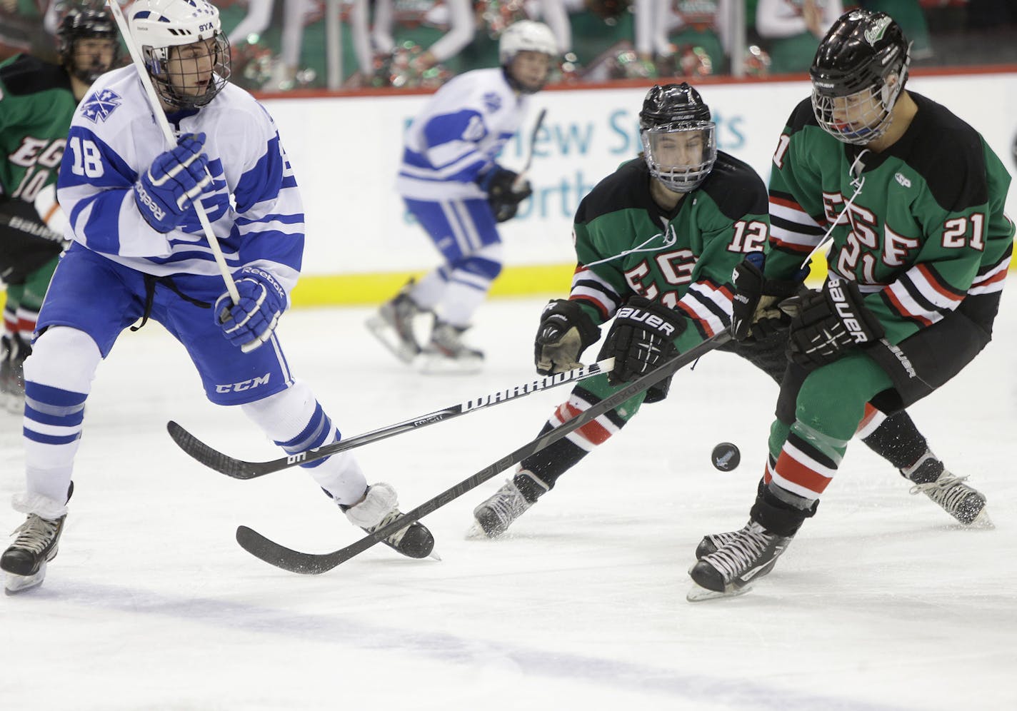 St. Thomas Academy's Austin Sattler and East Grand Forks' Tye Ausmus and Rayce Martin battled for the puck during the first period of the Class 1A boys' hockey state tournament semifinals at the Xcel Energy Center, Thursday, March 8, 2013 in St. Paul, MN.(ELIZABETH FLORES/STAR TRIBUNE) ELIZABETH FLORES &#x2022; eflores@startribune.com